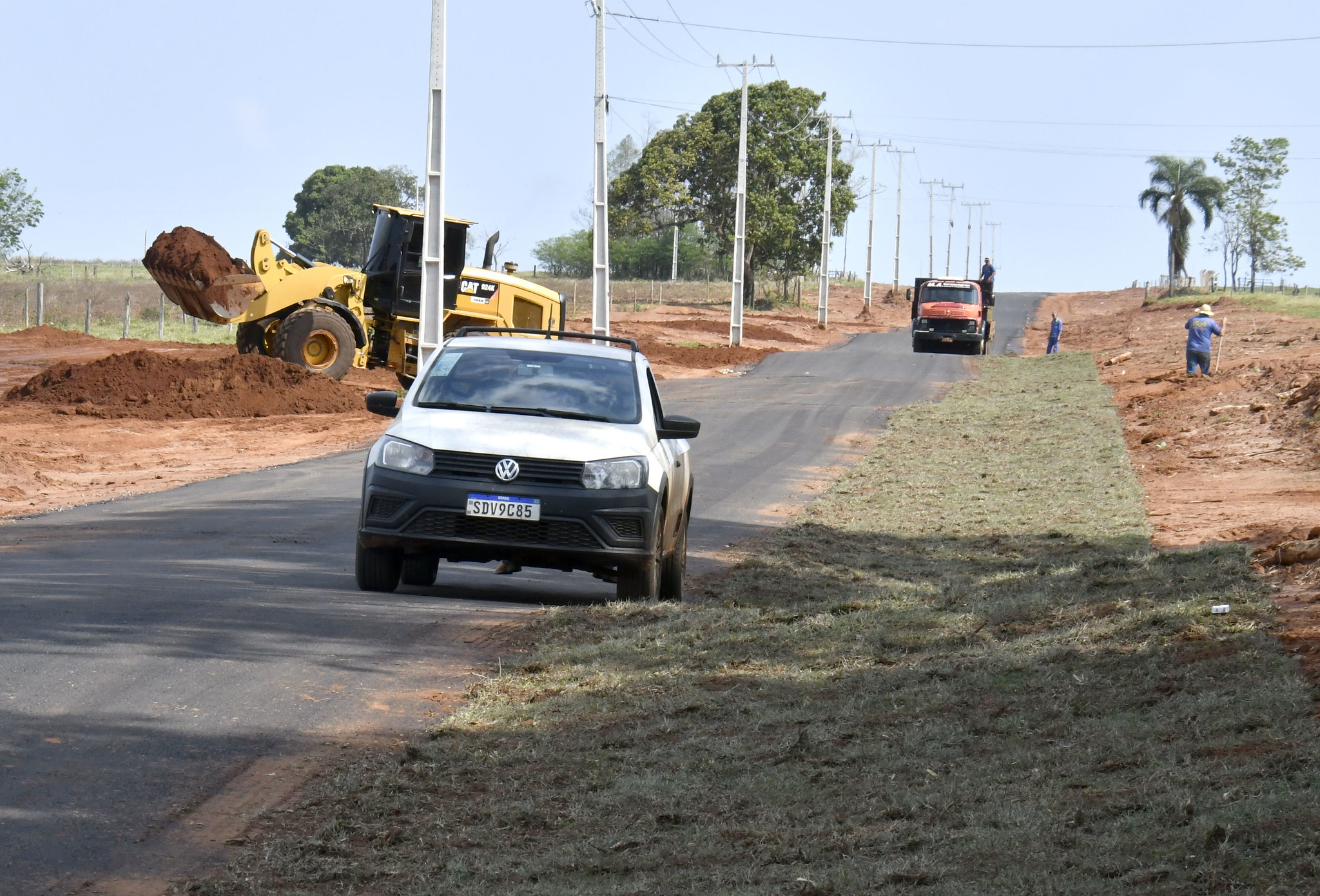 Veículo estacionado na margem da estrada já asfaltada, com plantio de grama nas laterais