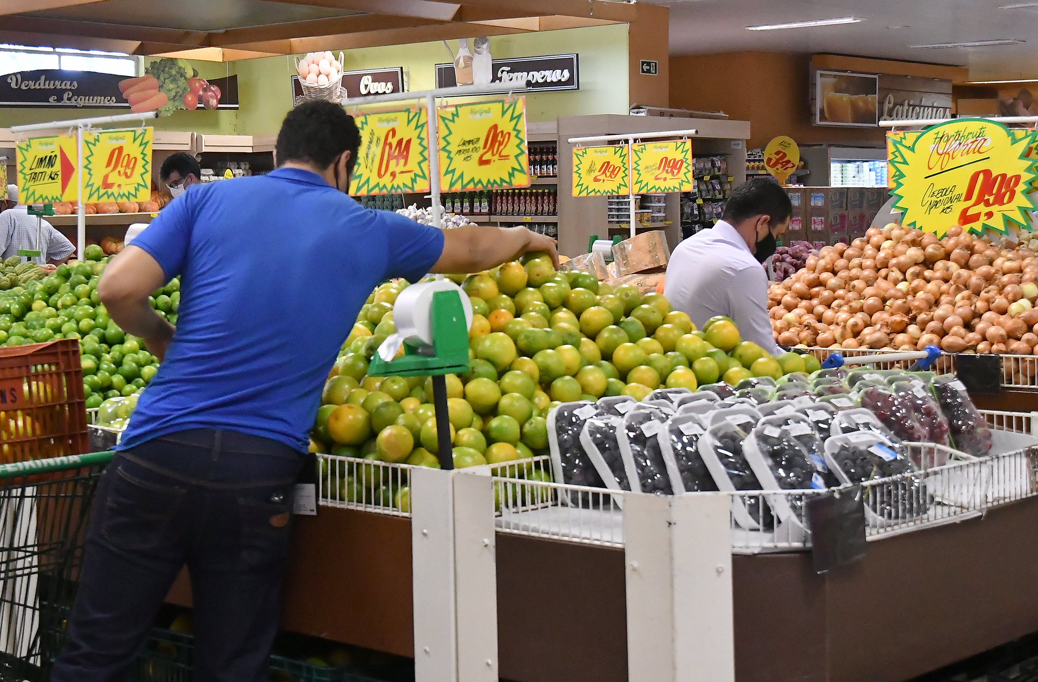 homem em supermercado banca de frutas e verduras