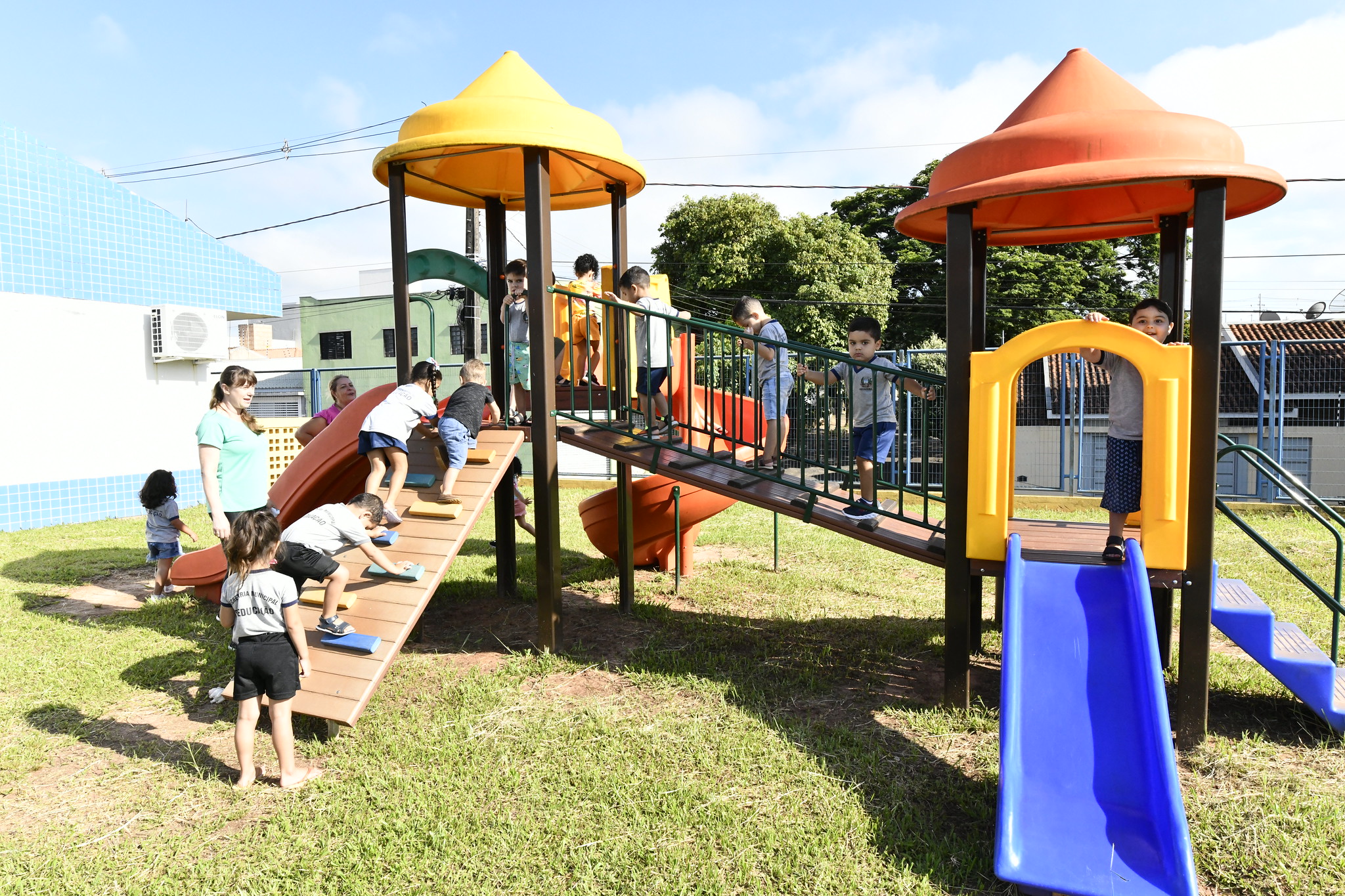 Crianças brincam em parque infantil no interior de escola municipal