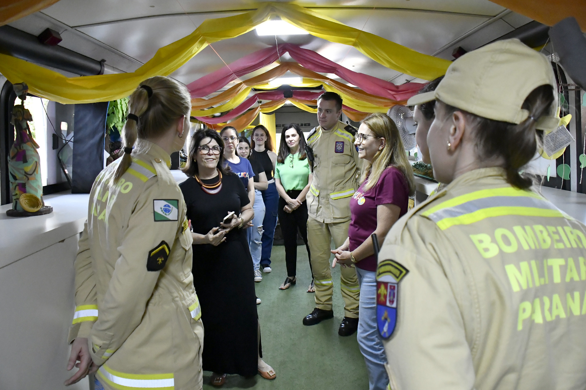 bombeiros e professoras dentro do ônibus da biblioteca itinerante