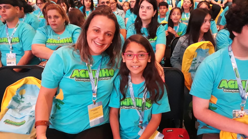 Professora e aluno premiados no projeto agrinho 2023 posam para foto