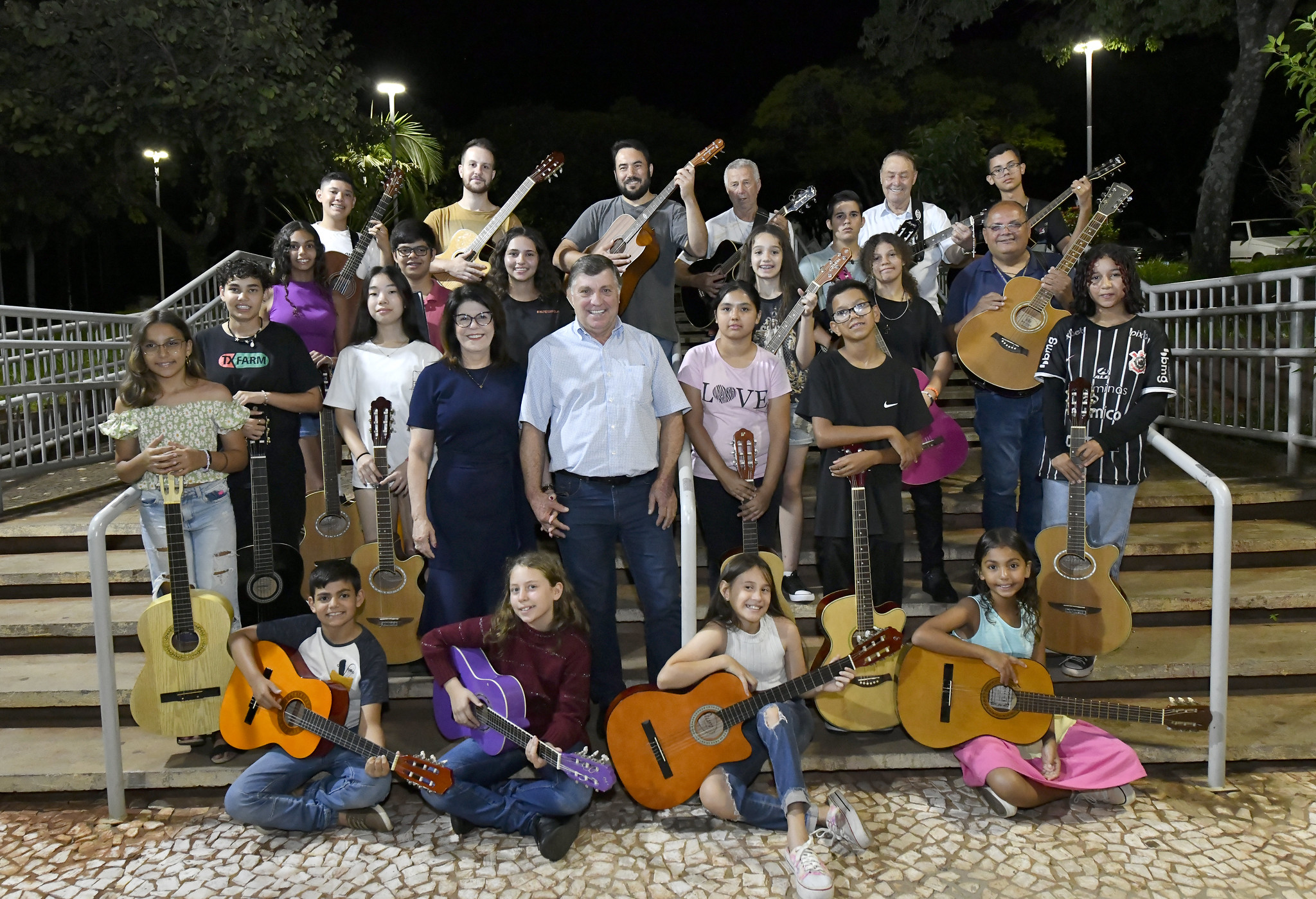 Prefeito e primeira-dama com professor Sandro Luiz e alunos com violões na mão