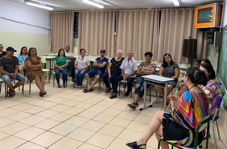 pessoas reunidas em uma sala conversando em um circulo de cadeiras
