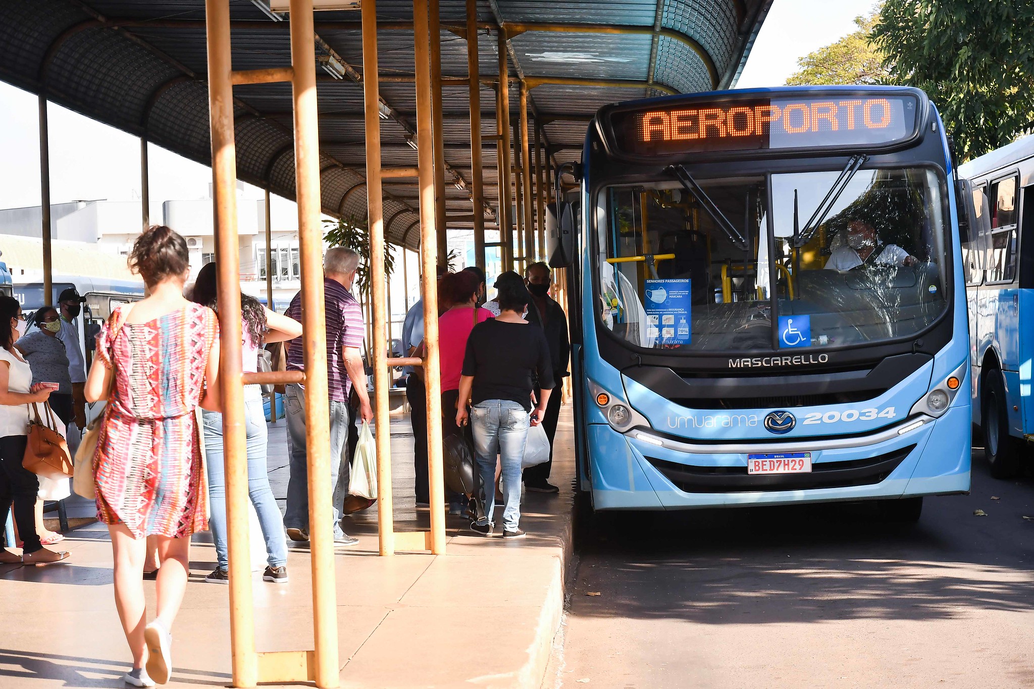 ônibus parado no terminal e passageiros embarcando
