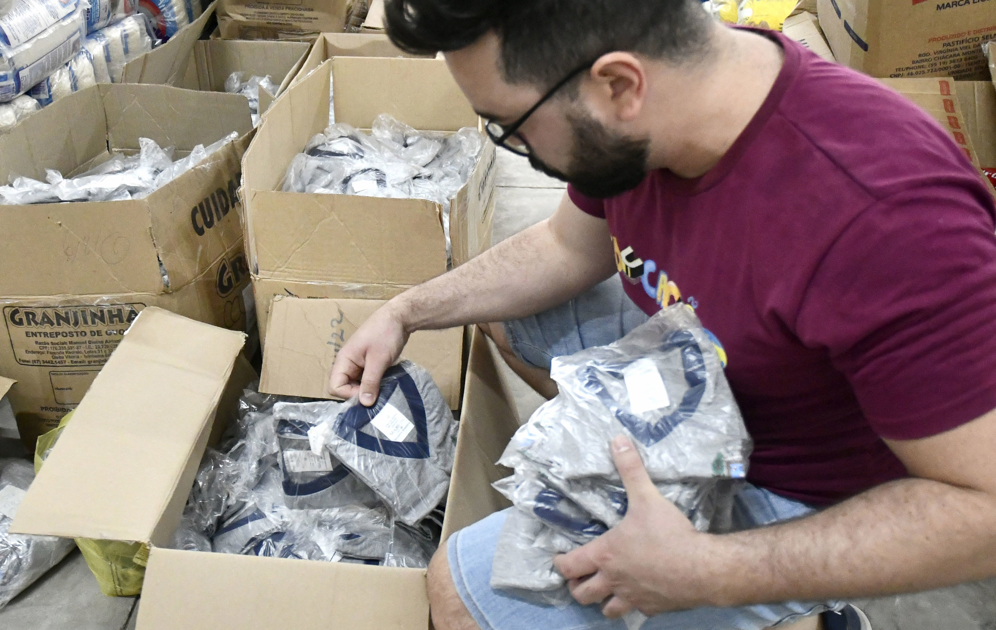 funcionário avalia qualidade de camisetas escolares