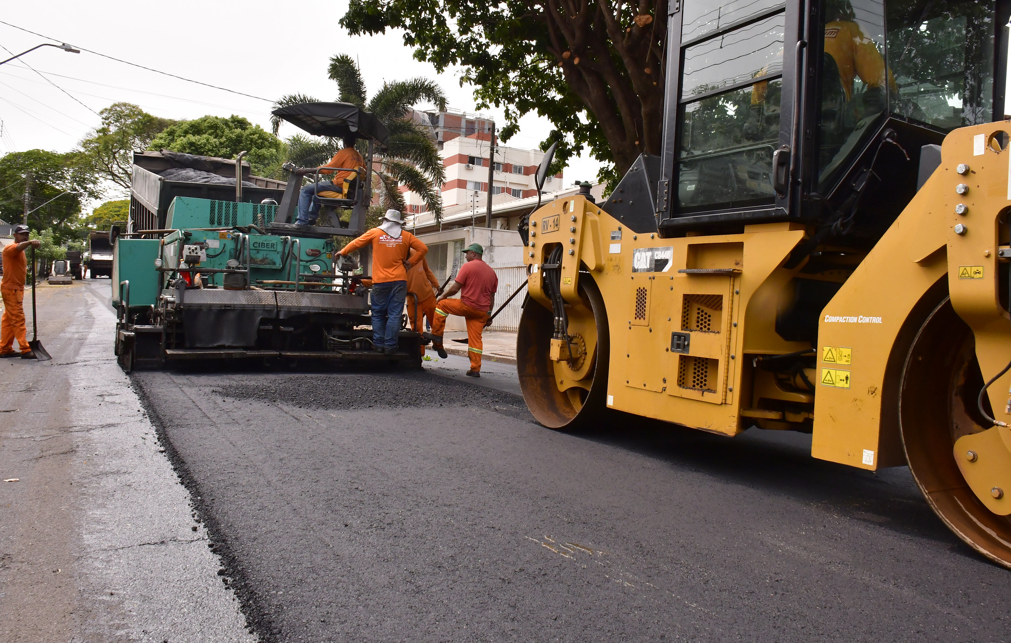 rolo compactador e niveladora de asfalto em trabalho, no recapeamento