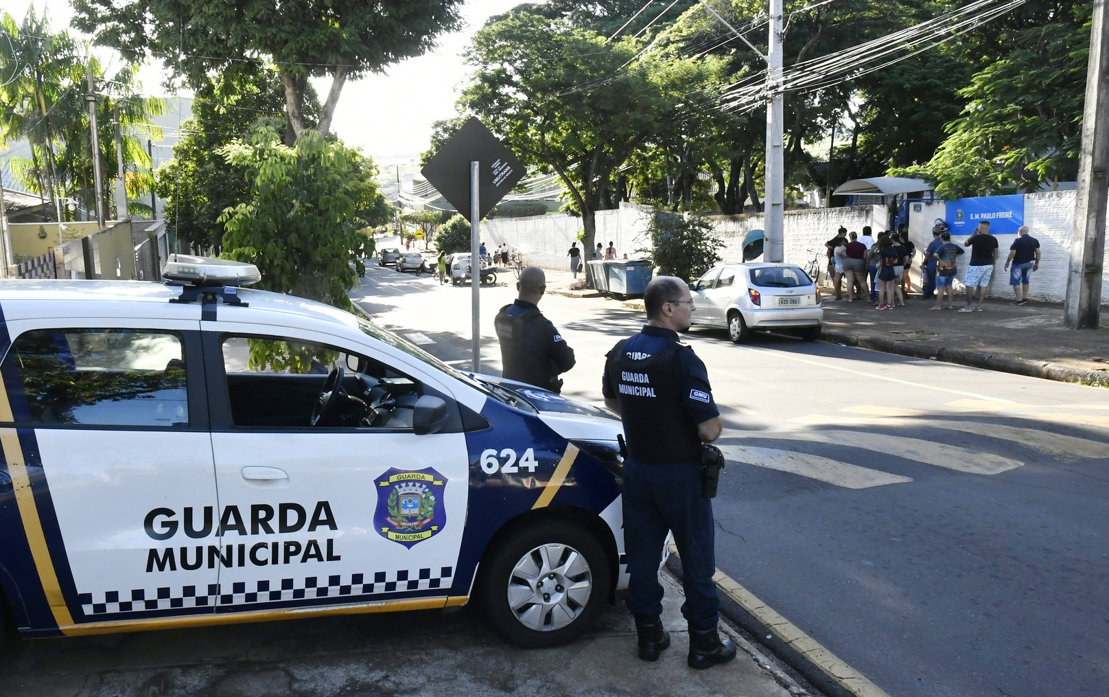 guardas municipais observam movimento na frente de unidade educacional