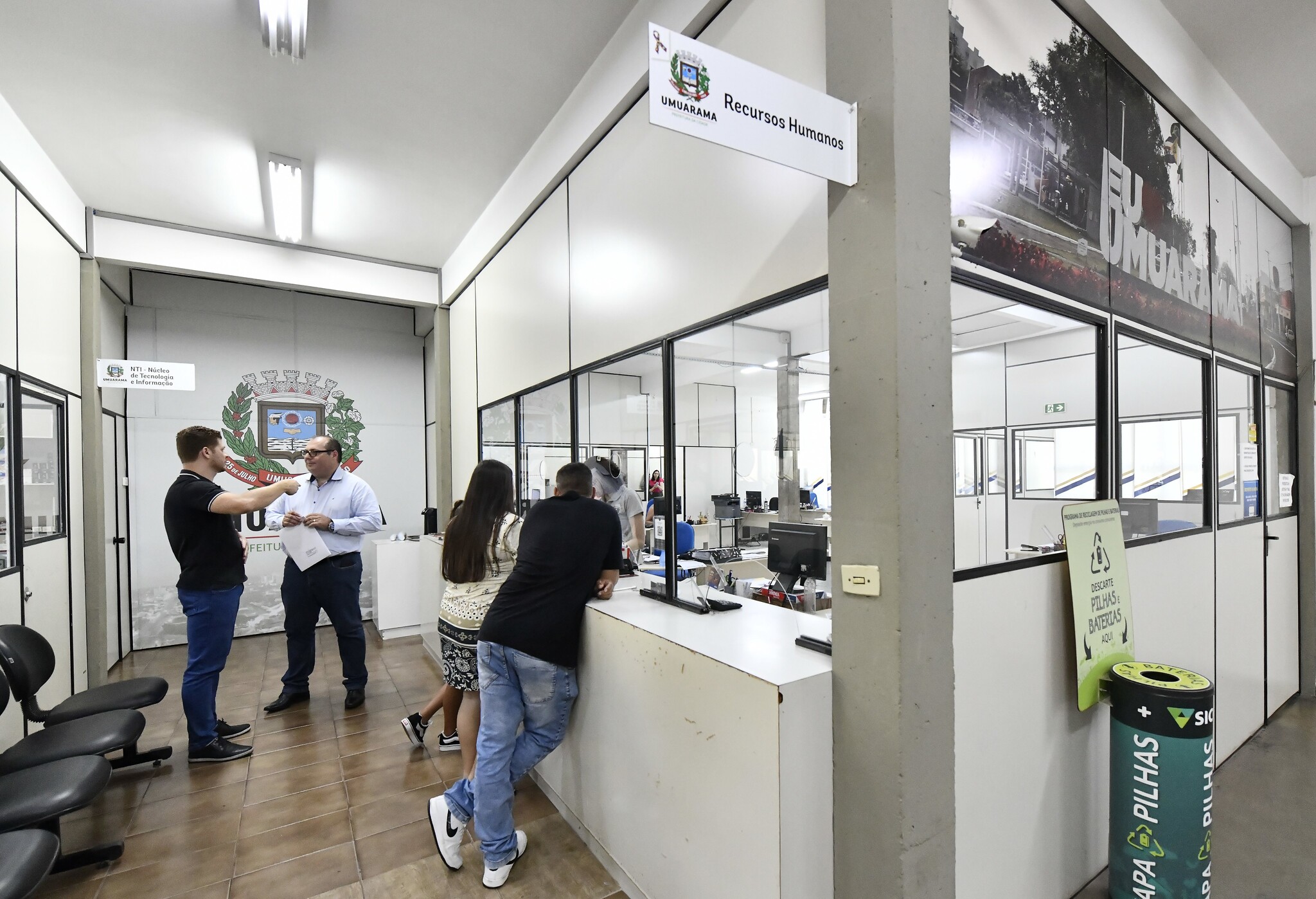 pessoas aguardando atendimento no balcão do setor de recursos humanos da prefeitura