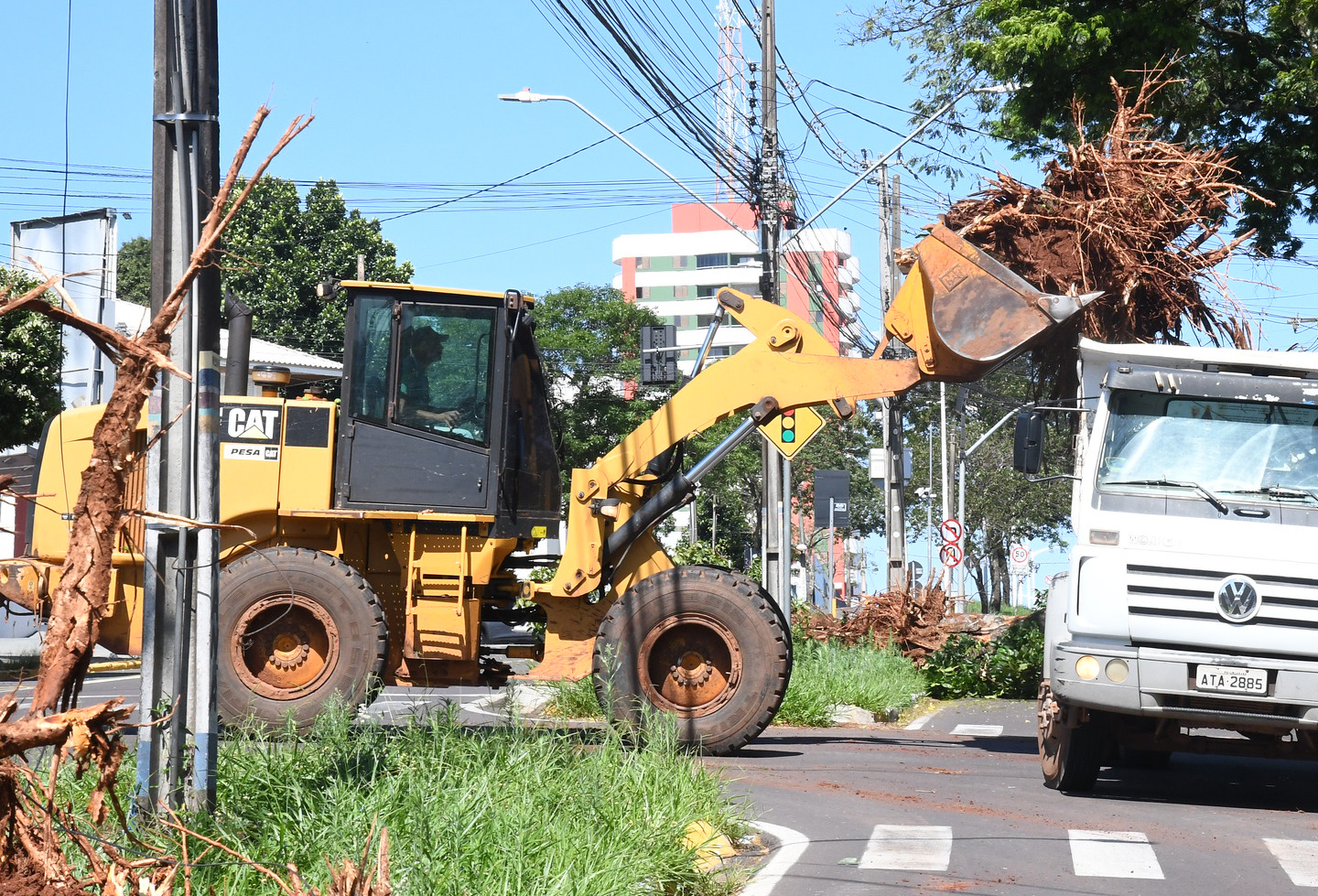 imagem de pá carregadeira colocando resíduos na carroceria de um caminhão