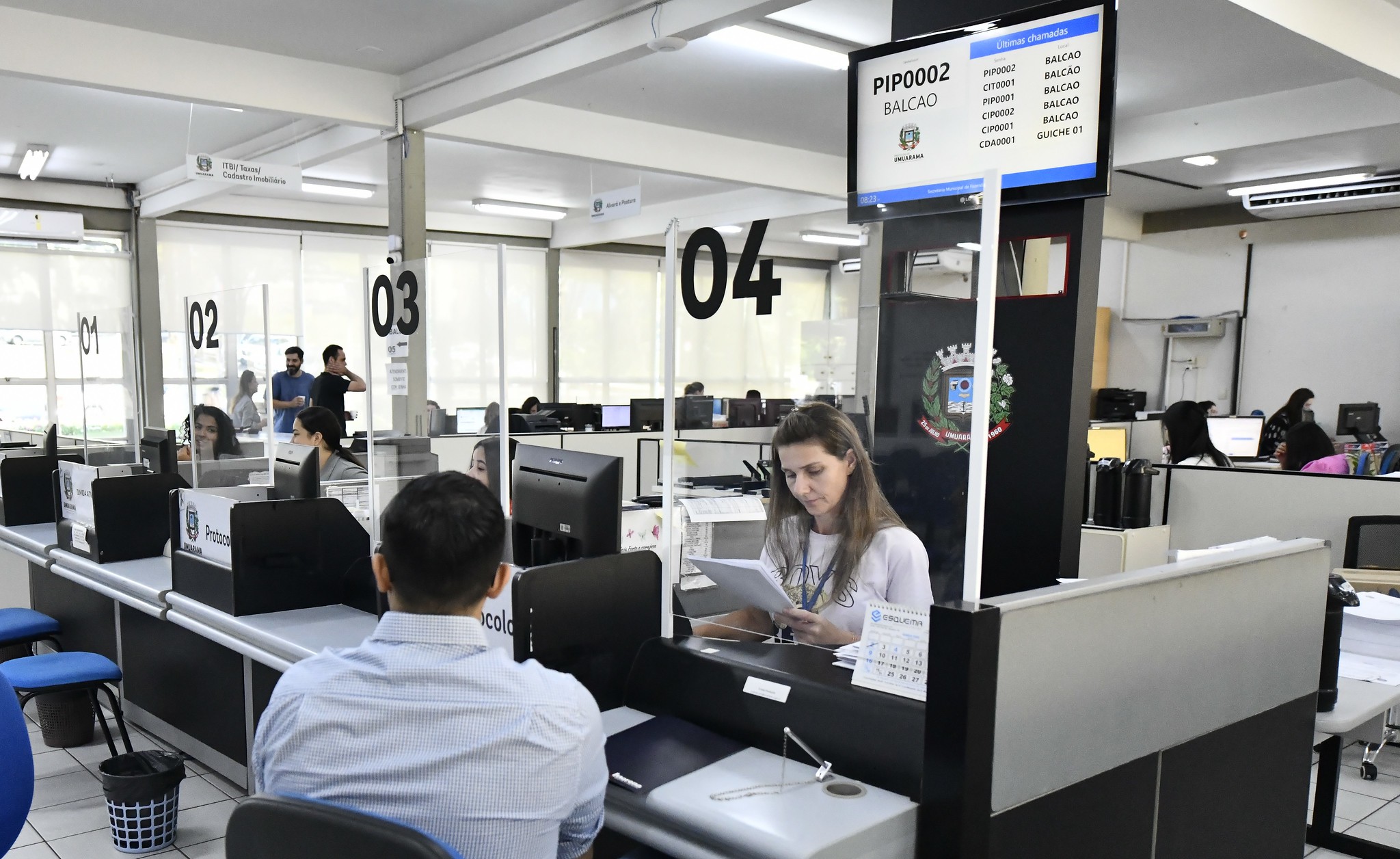 imagem do balcão de atendimento aos contribuintes no prédio da prefeitura, com pessoas sendo atendidas