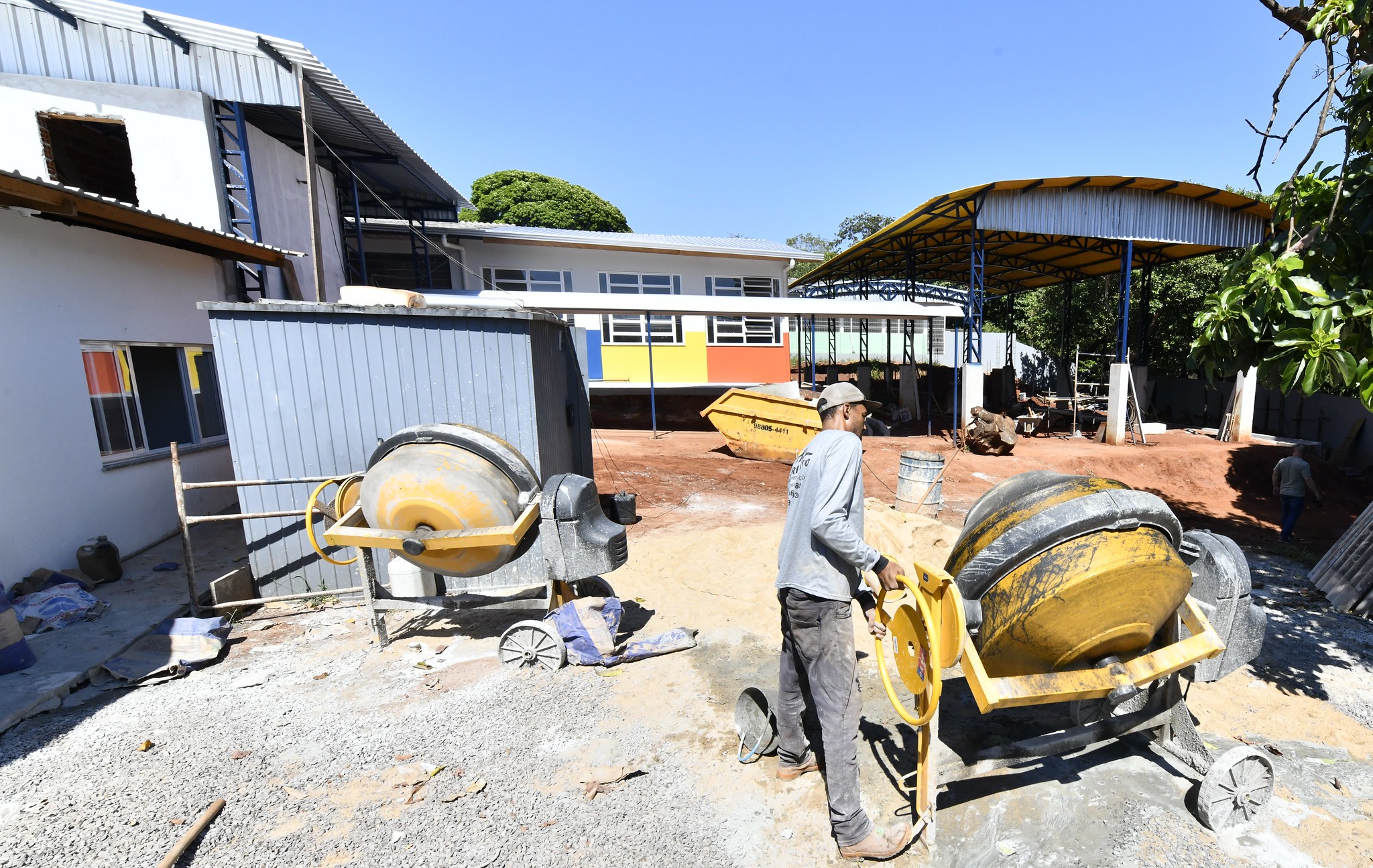 imagem de trabalhador preparando concreto para obra em betoneira