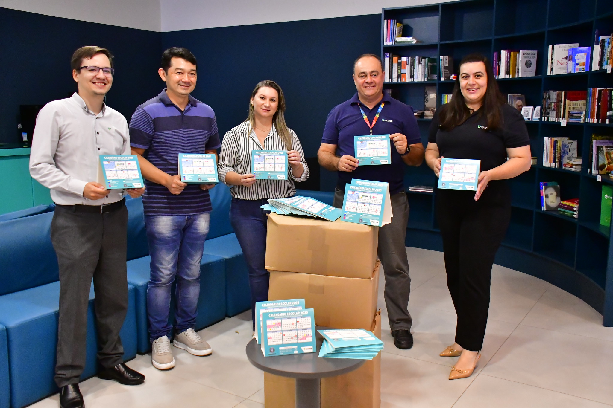 gerentes do banco e q equipe da secretaria de educação mostram os calendários recebidos nesta quinta-feira