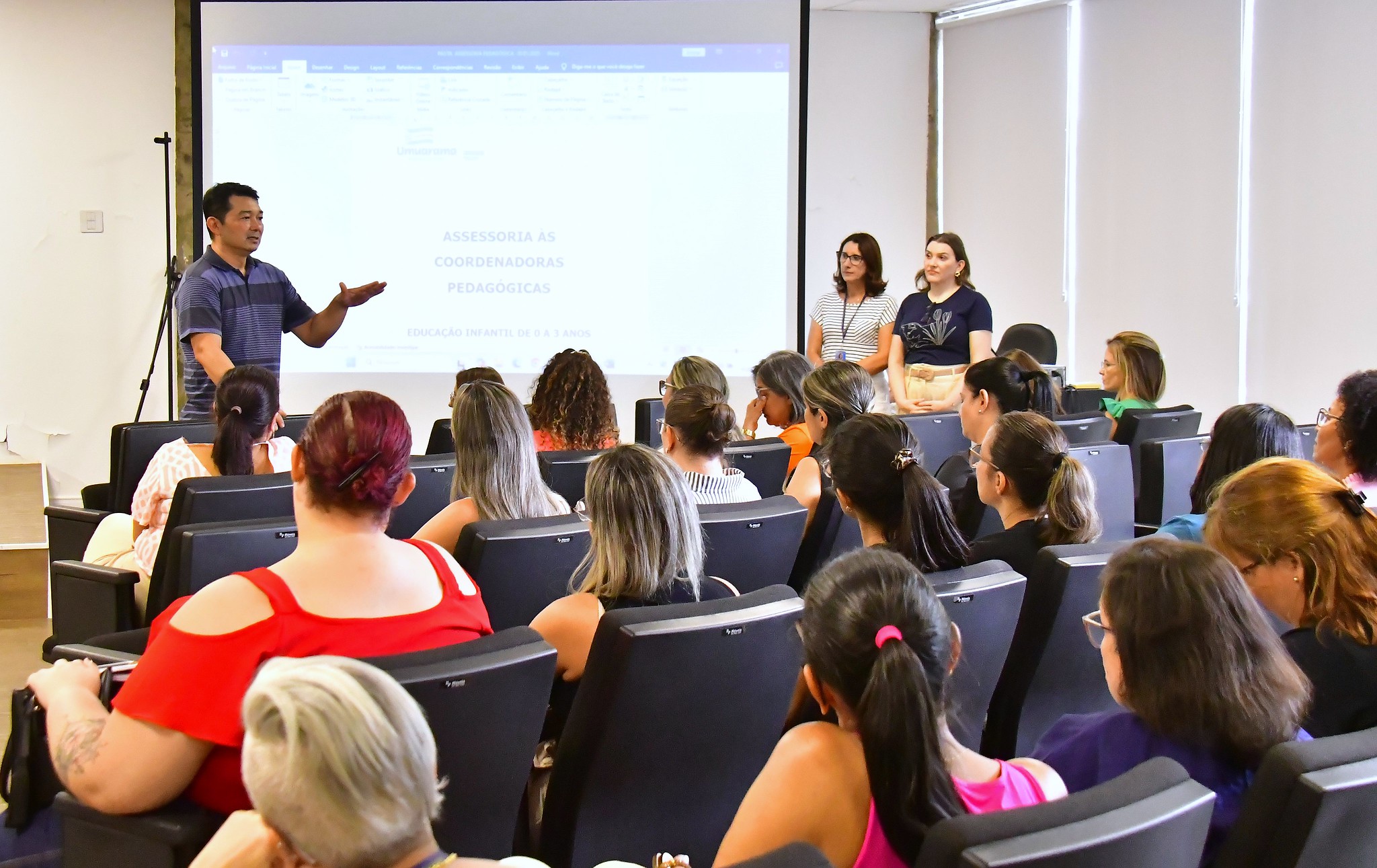 professor fala para plateia no auditório da prefeitura