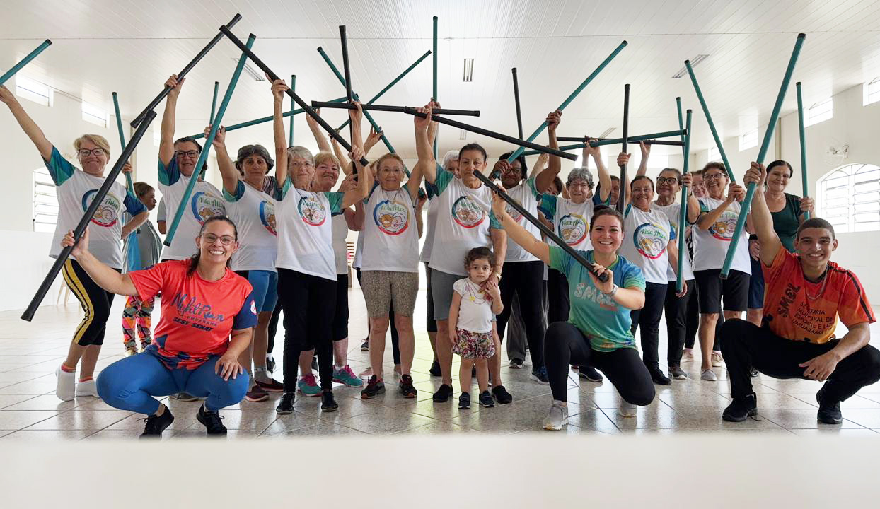 grupo de idosos posa para foto em atividade com barras de apoio