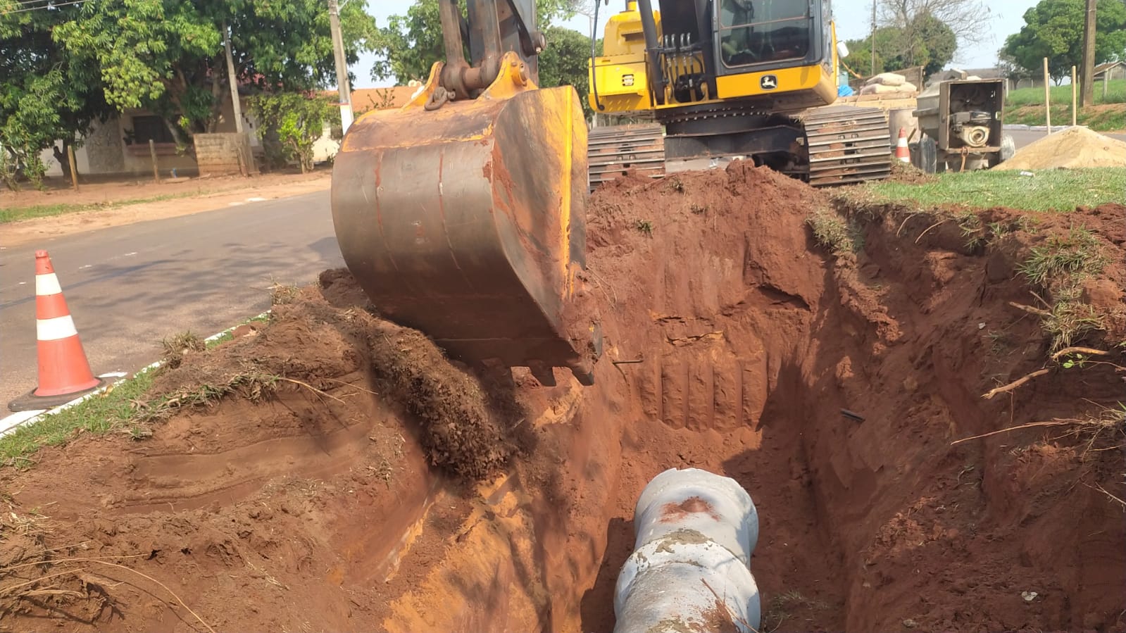 máquina cobrindo tubulação pluvial com terra