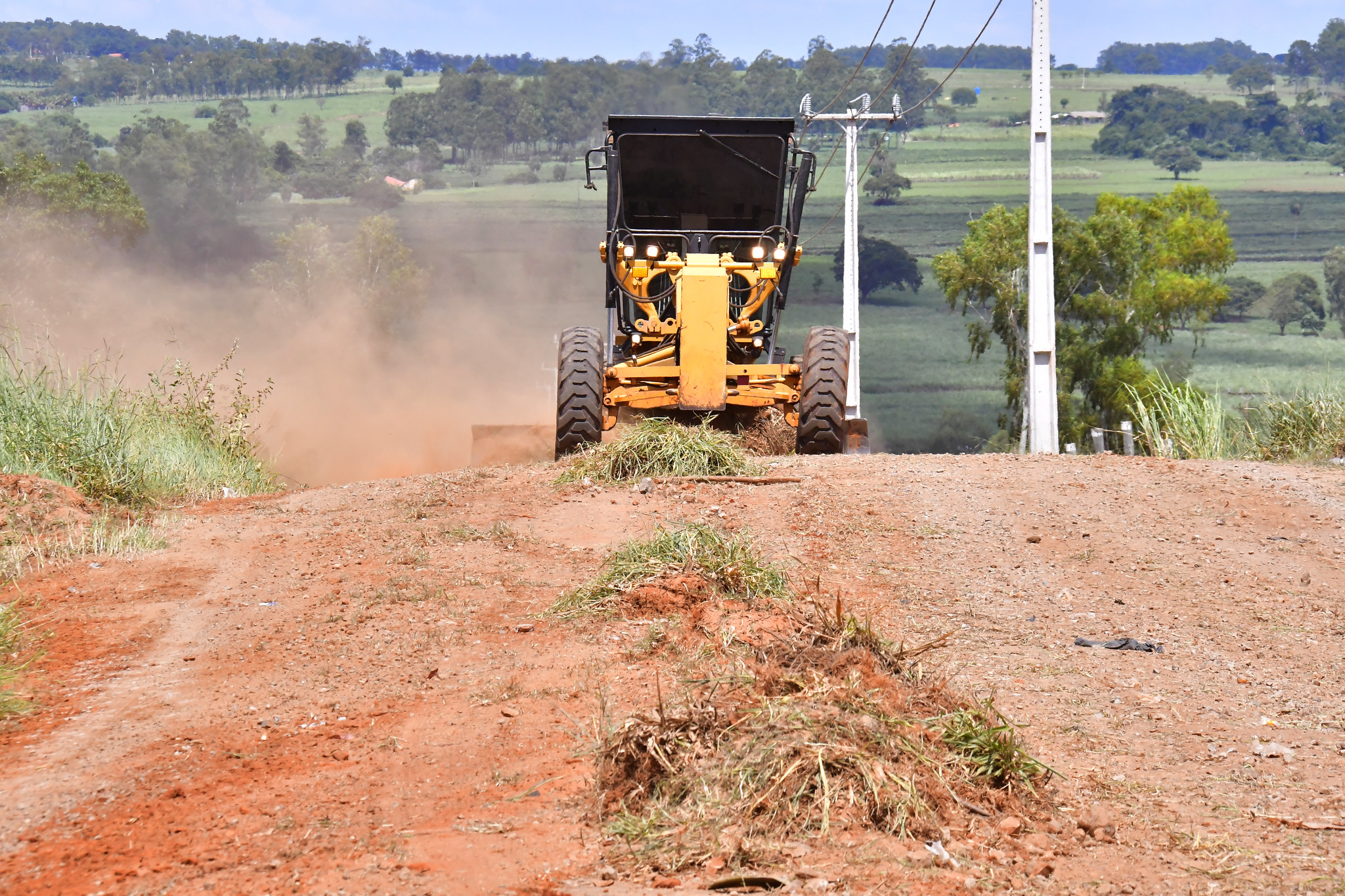 motoniveladora executa serviço de manutenção em estrada rural sem asfalto