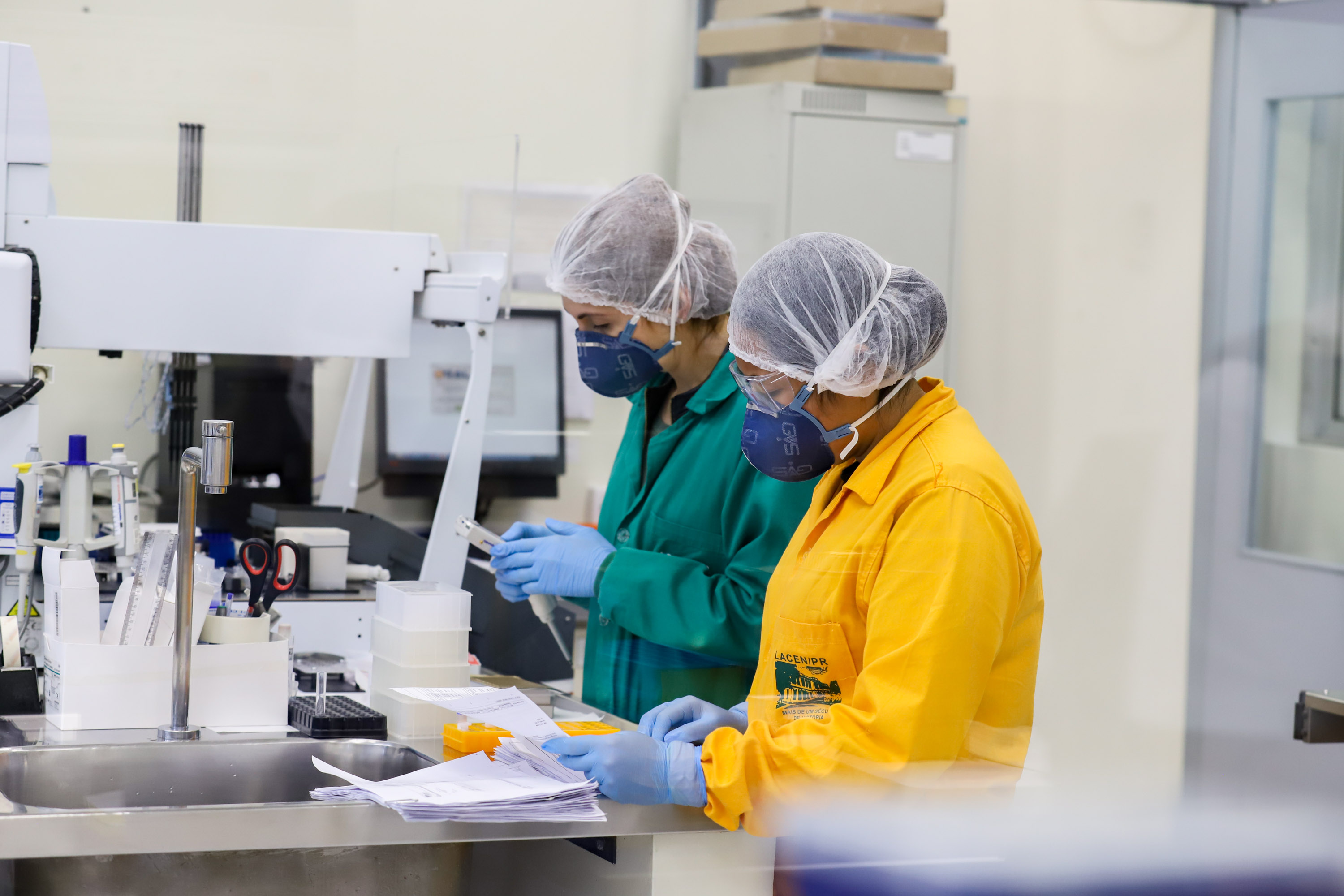 técnicos realizam exames laboratoriais