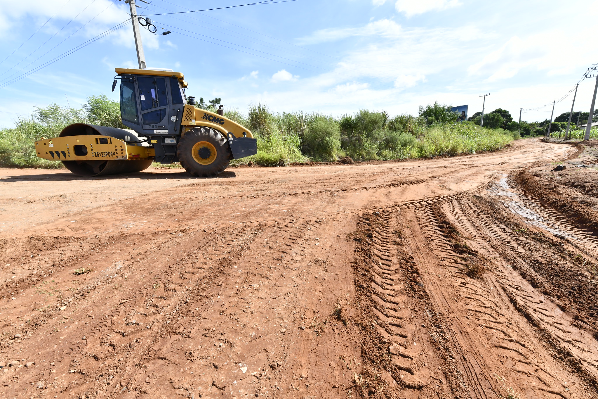 rolo compactador trafega sobre a estrada rural