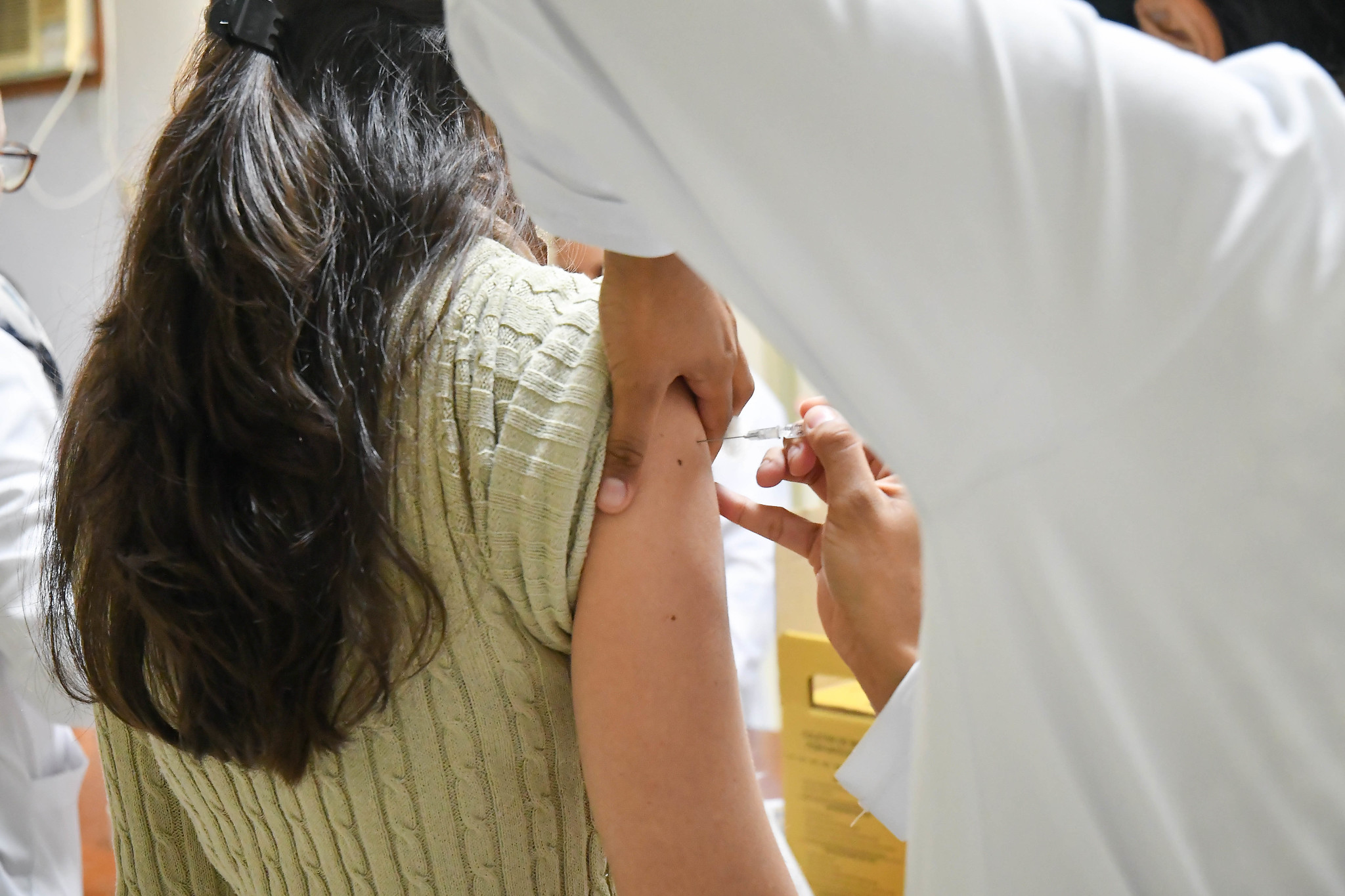 menina recebe vacina no braço
