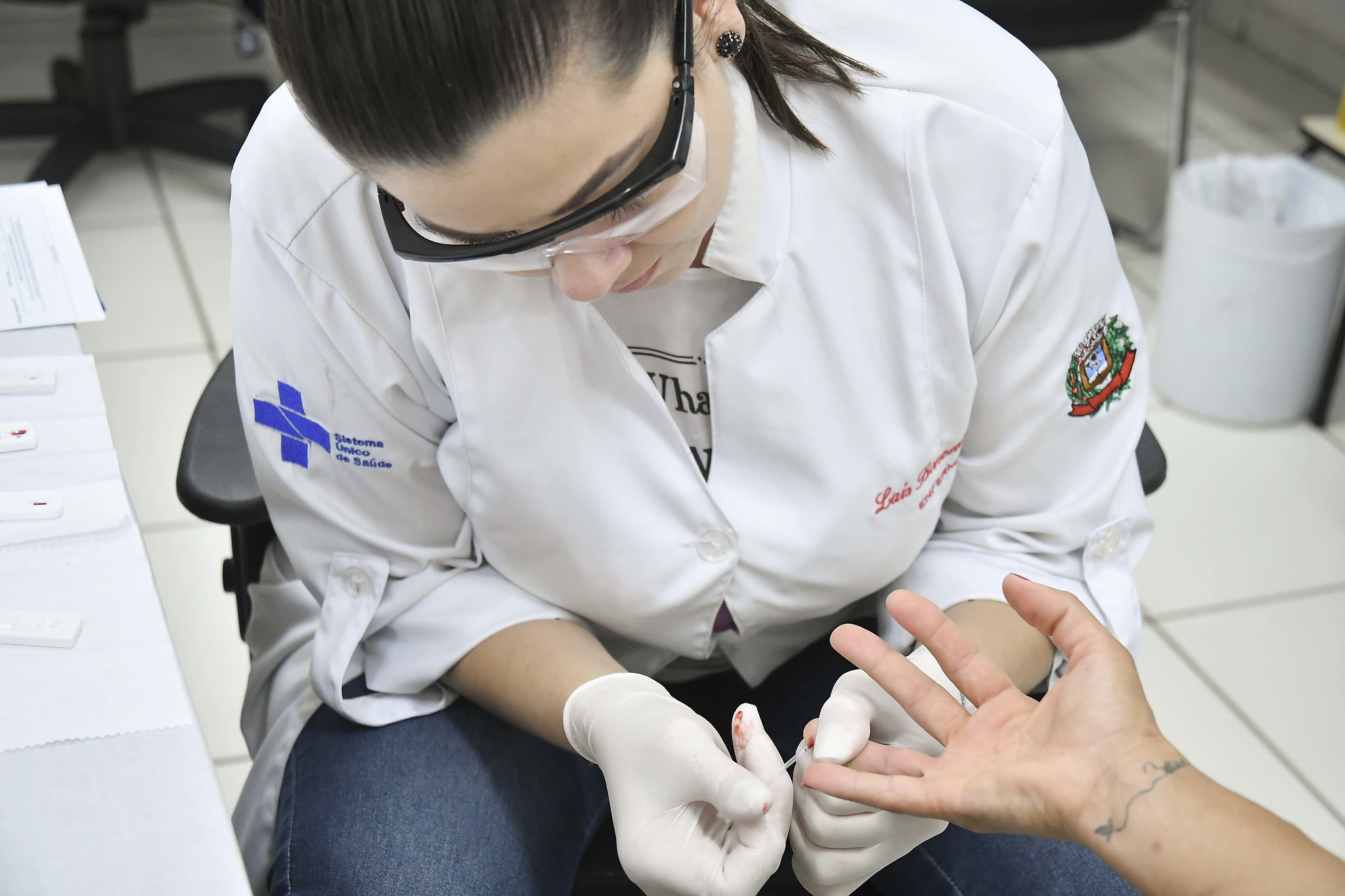 enfermeira coleta sangue na mão de paciente para teste rápido de covid-19