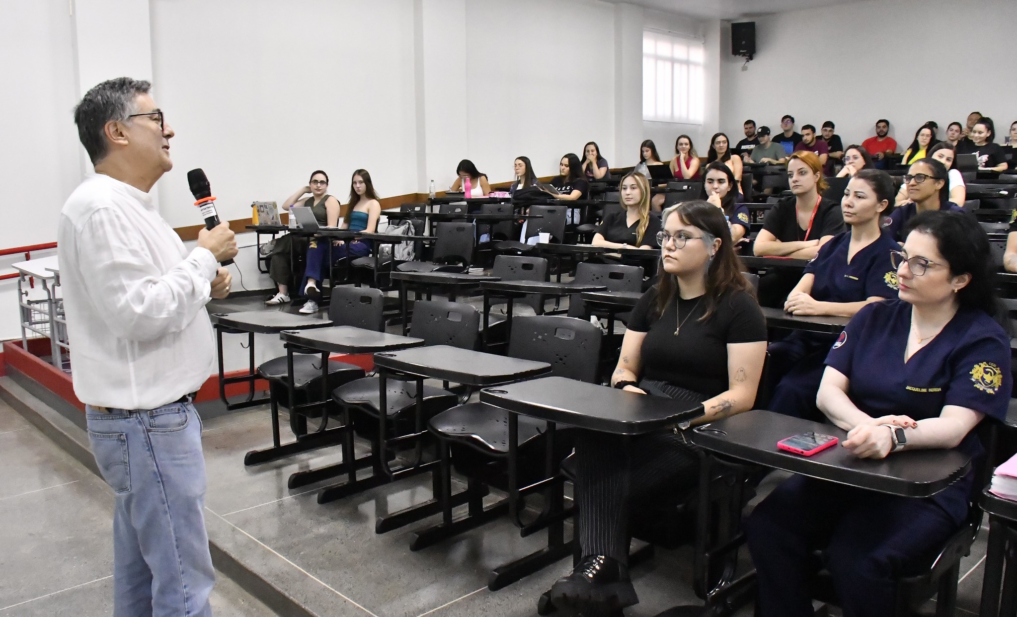 médico fala aos alunos no auditório da universidade
