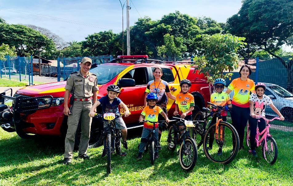 viatura do bombeiro, soldado e crianças com bicicletas na foto