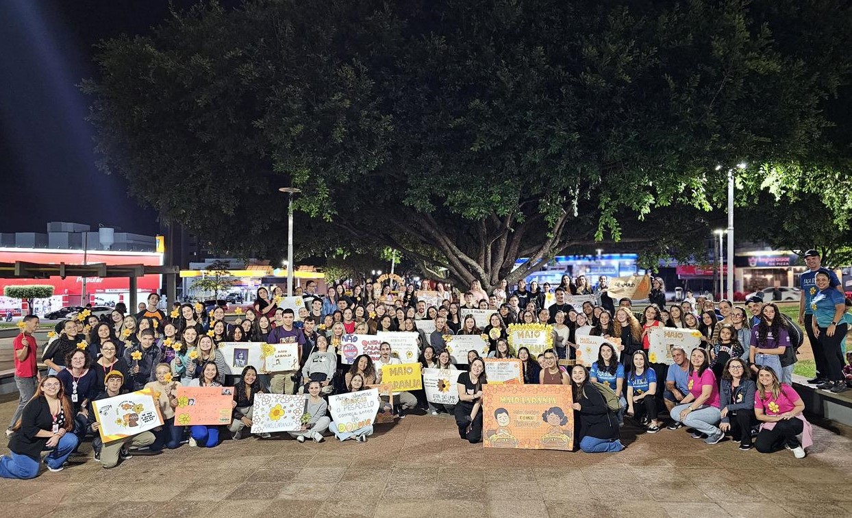 foto de parada da caminhada em praça da cidade, com cartazes e participantes