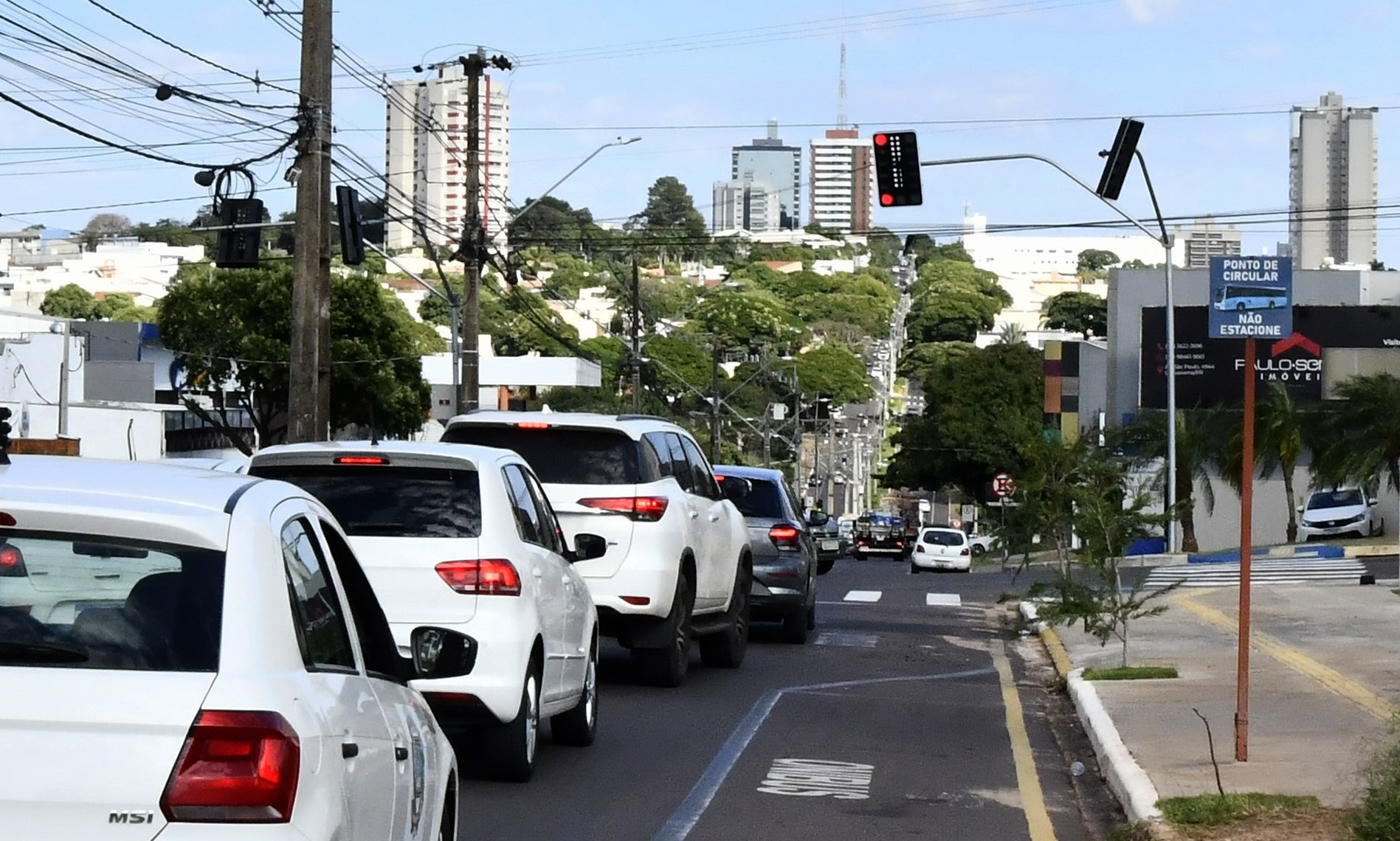 imagem do trânsito parado no novo semáforo, com a cidade ao fundo