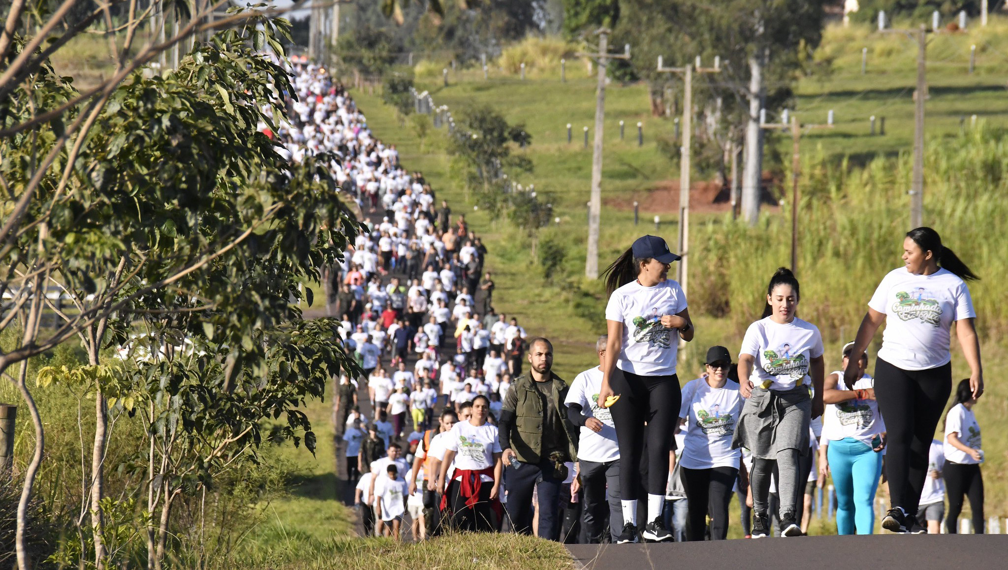 imagem da caminhada com centenas de pessoas andando em uma estrada rural