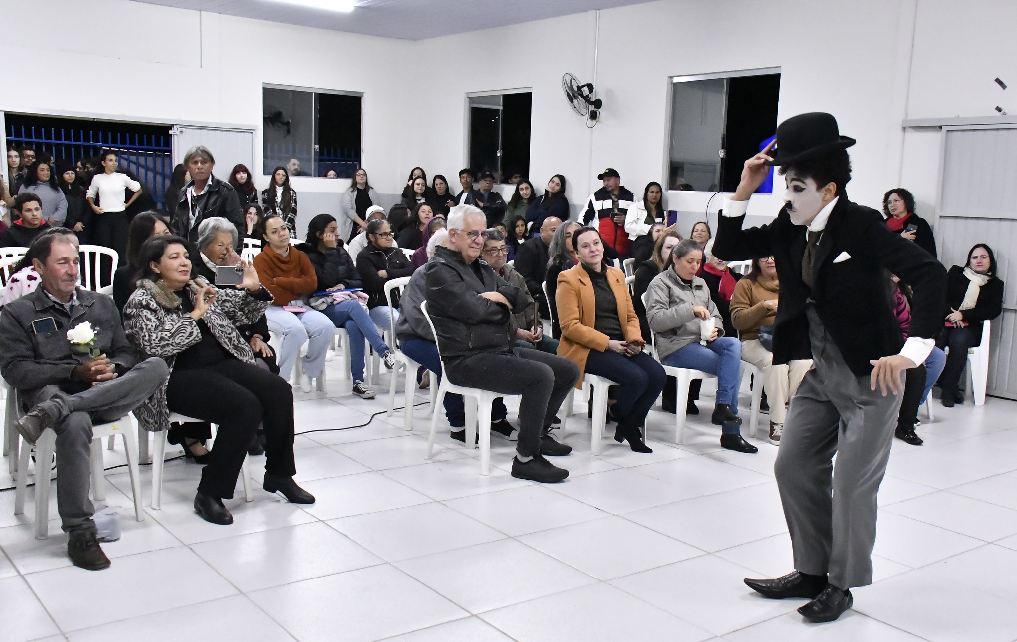 artista vestido como charlie chaplin se apresenta para o público