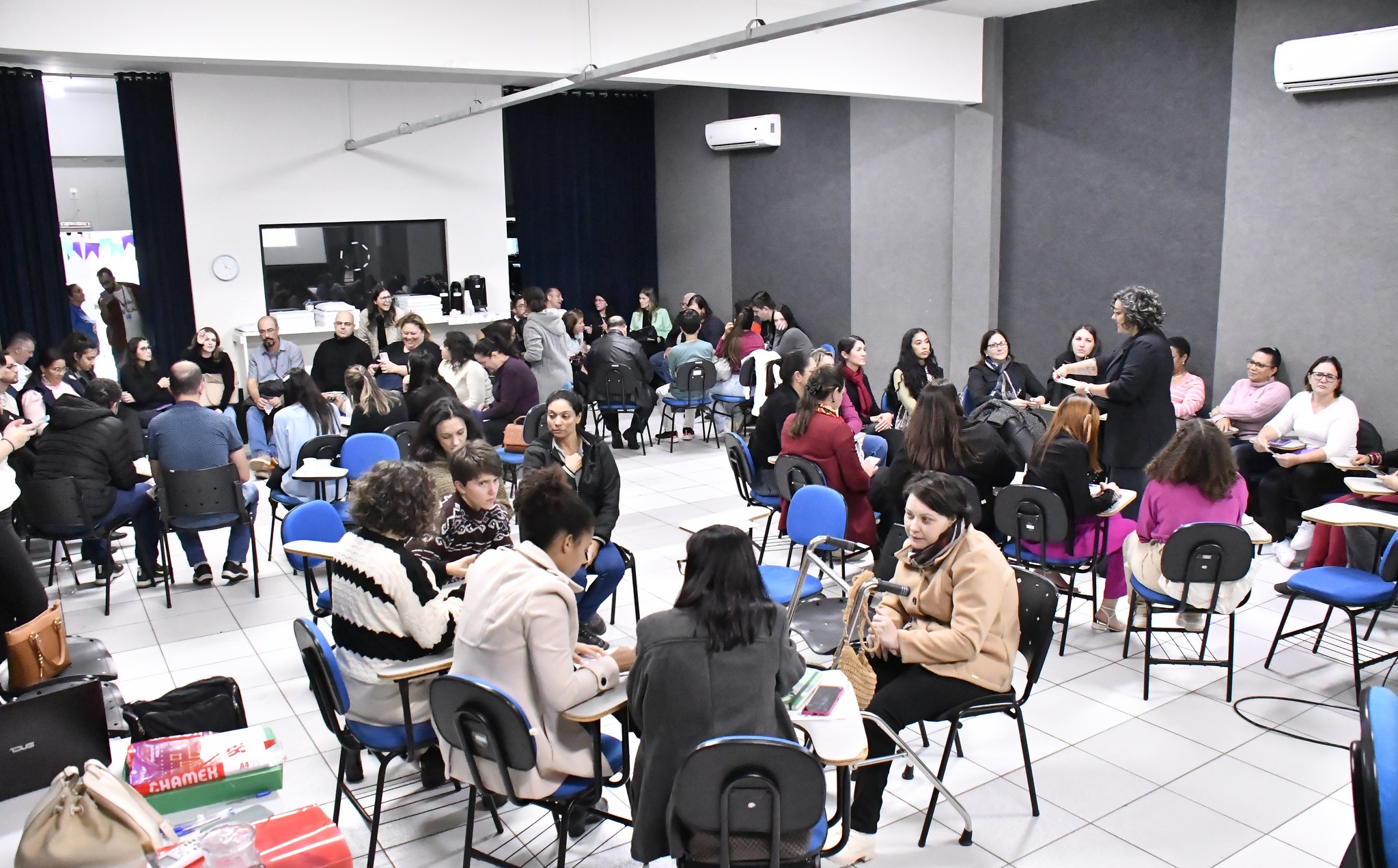 Foto dos grupos de pessoas reunidas em um auditório discutindo a organização da conferência municipal