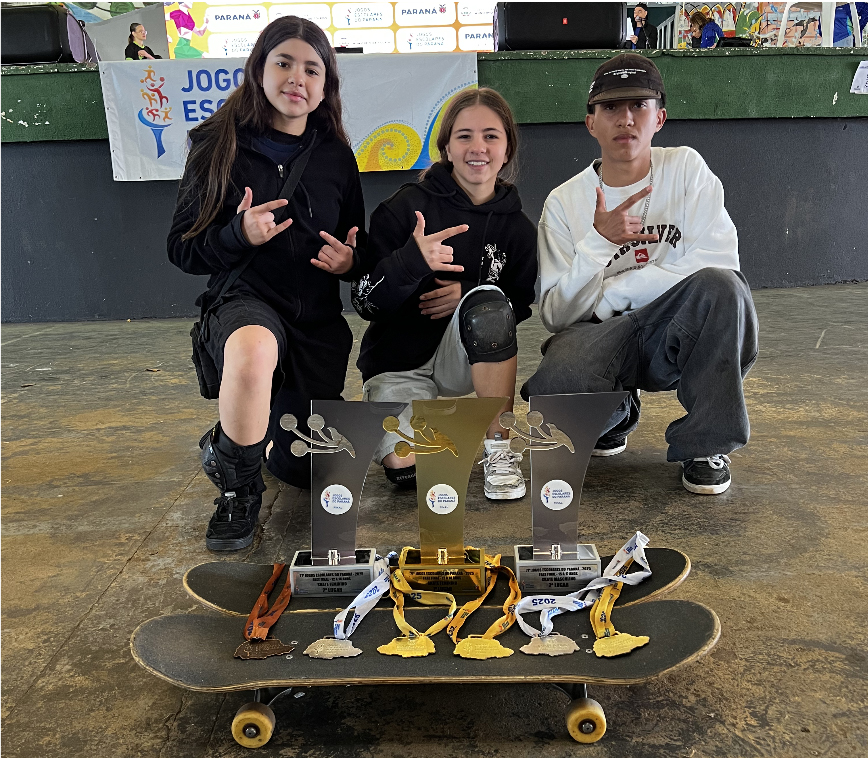 atletas que conseguiram premiações posam para imagem com troféus e skates