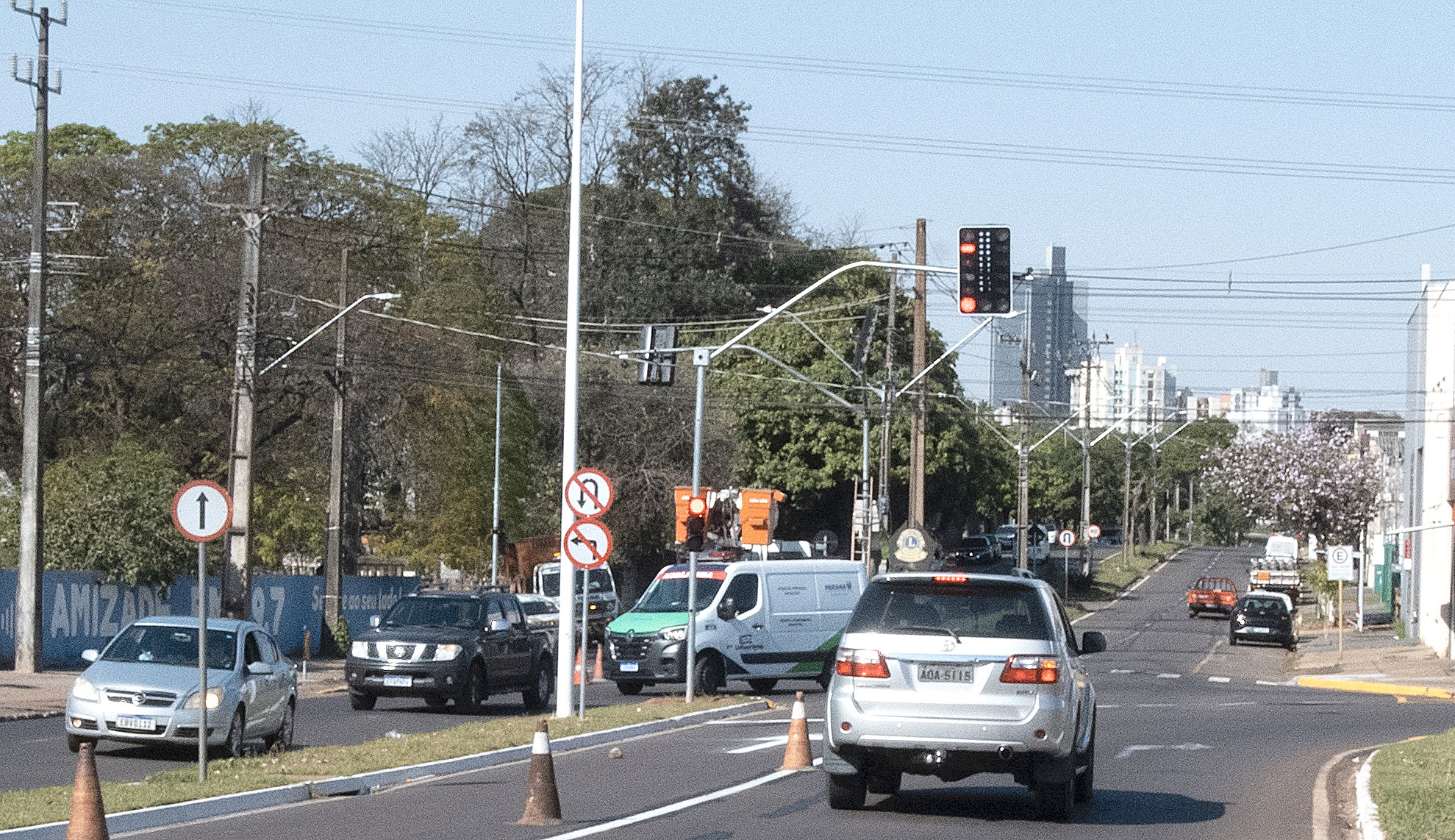 semáforo novo instalado na avenida, com a cidade ao fundo