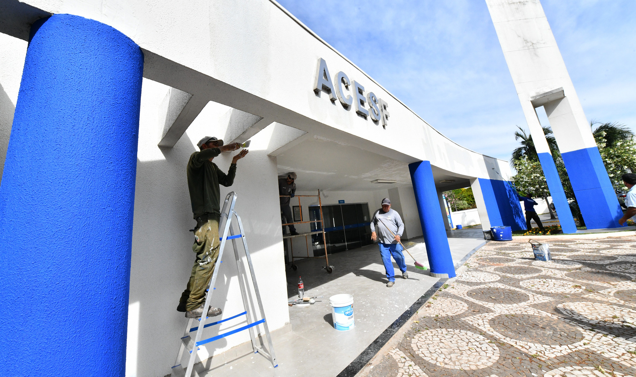 equipe de trabalhadores realiza limpeza e pintura de fachada da acesf
