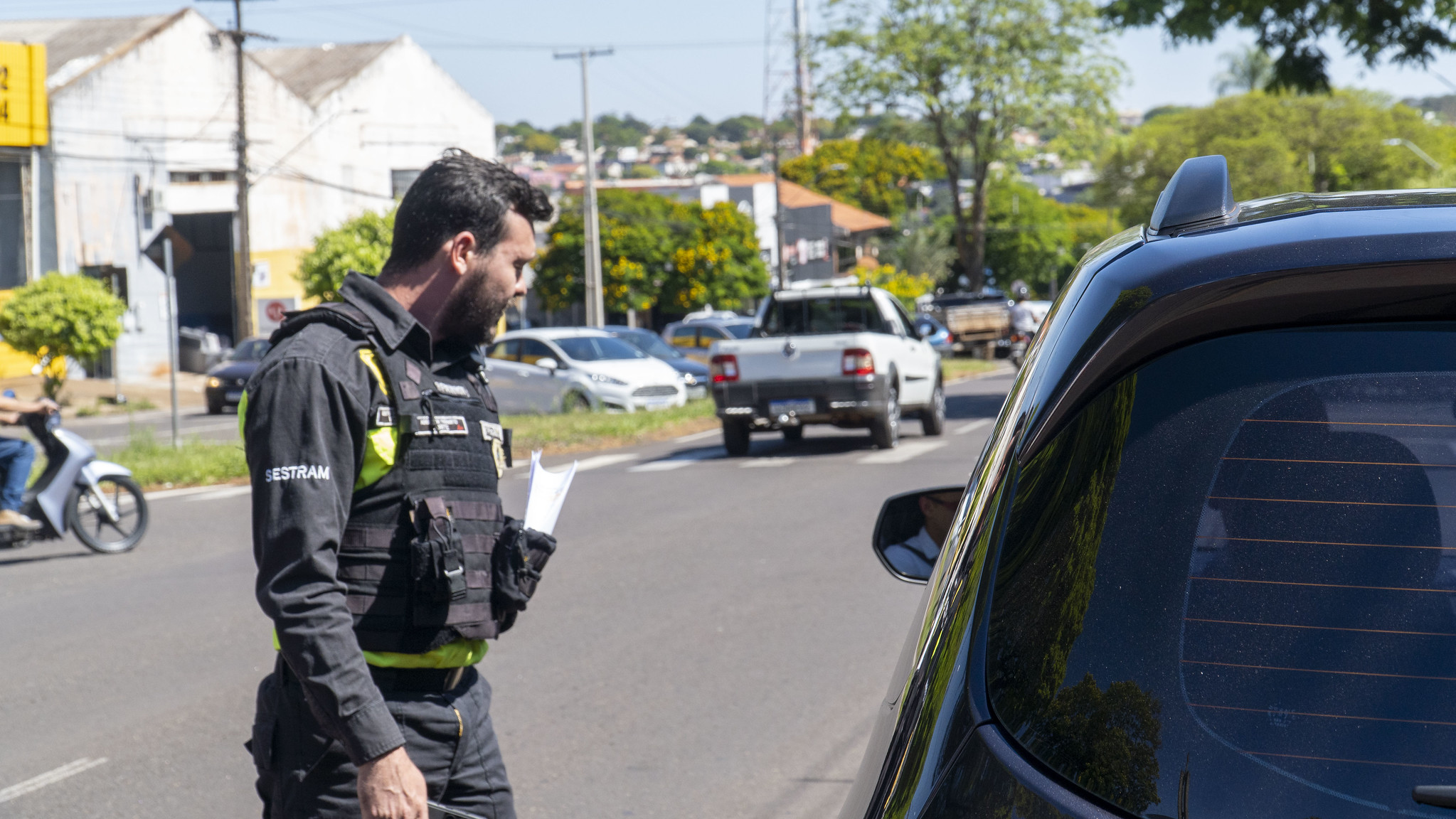 agente de trânsito fiscaliza veículo e orienta motorista