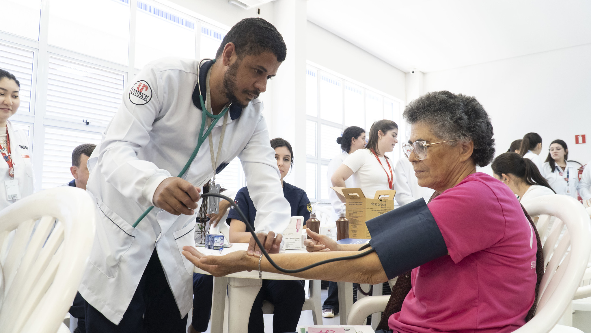 pessoa idosa é atendida por enfermeiro e mede a pressão arterial