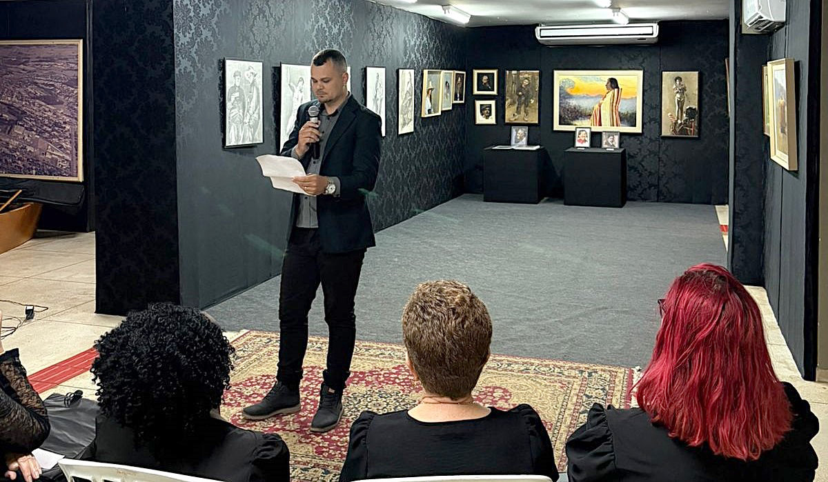 artista fala aos visitantes sobre as suas obras