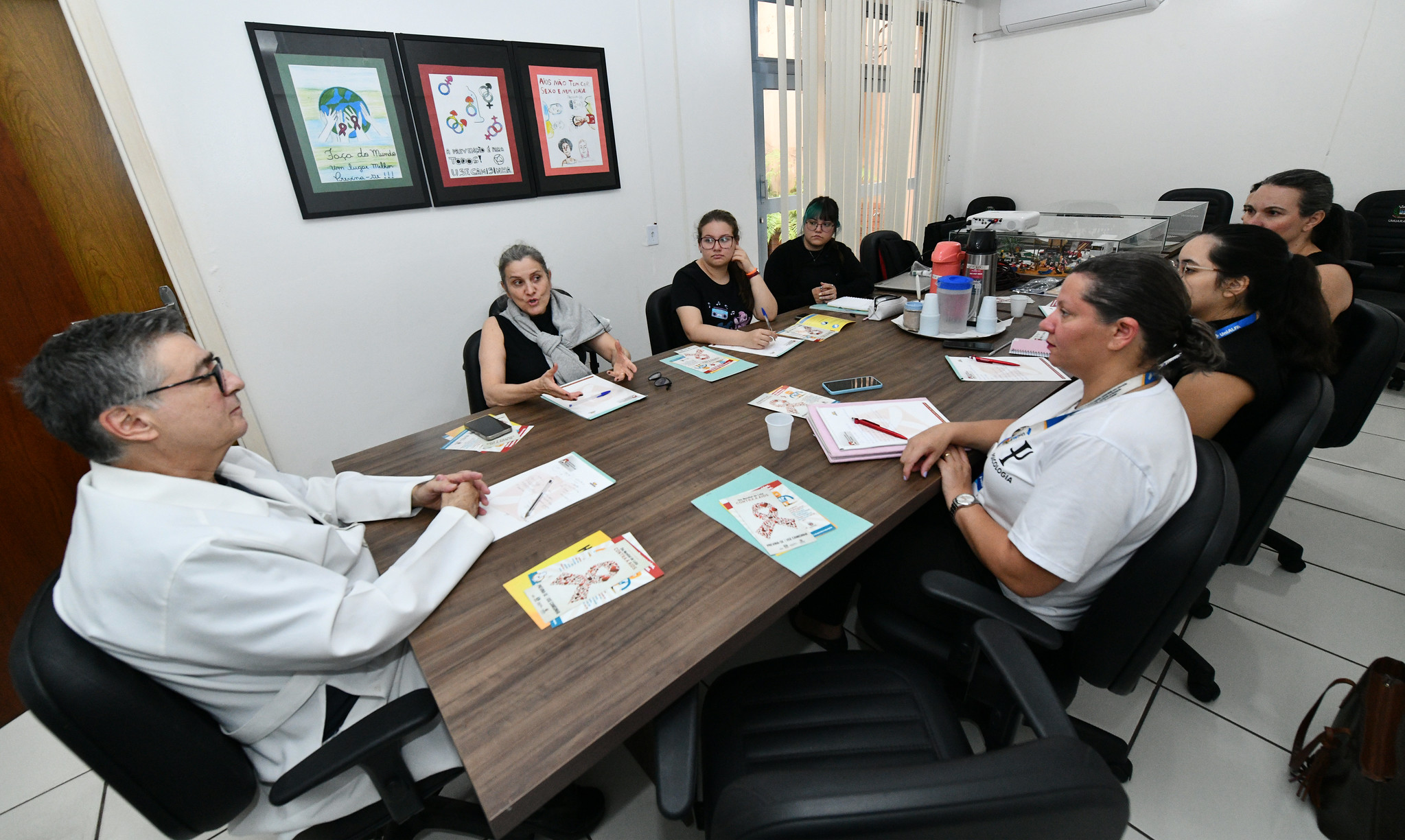 treinamento da equipe em volta de uma mesa, com o médico na ponta