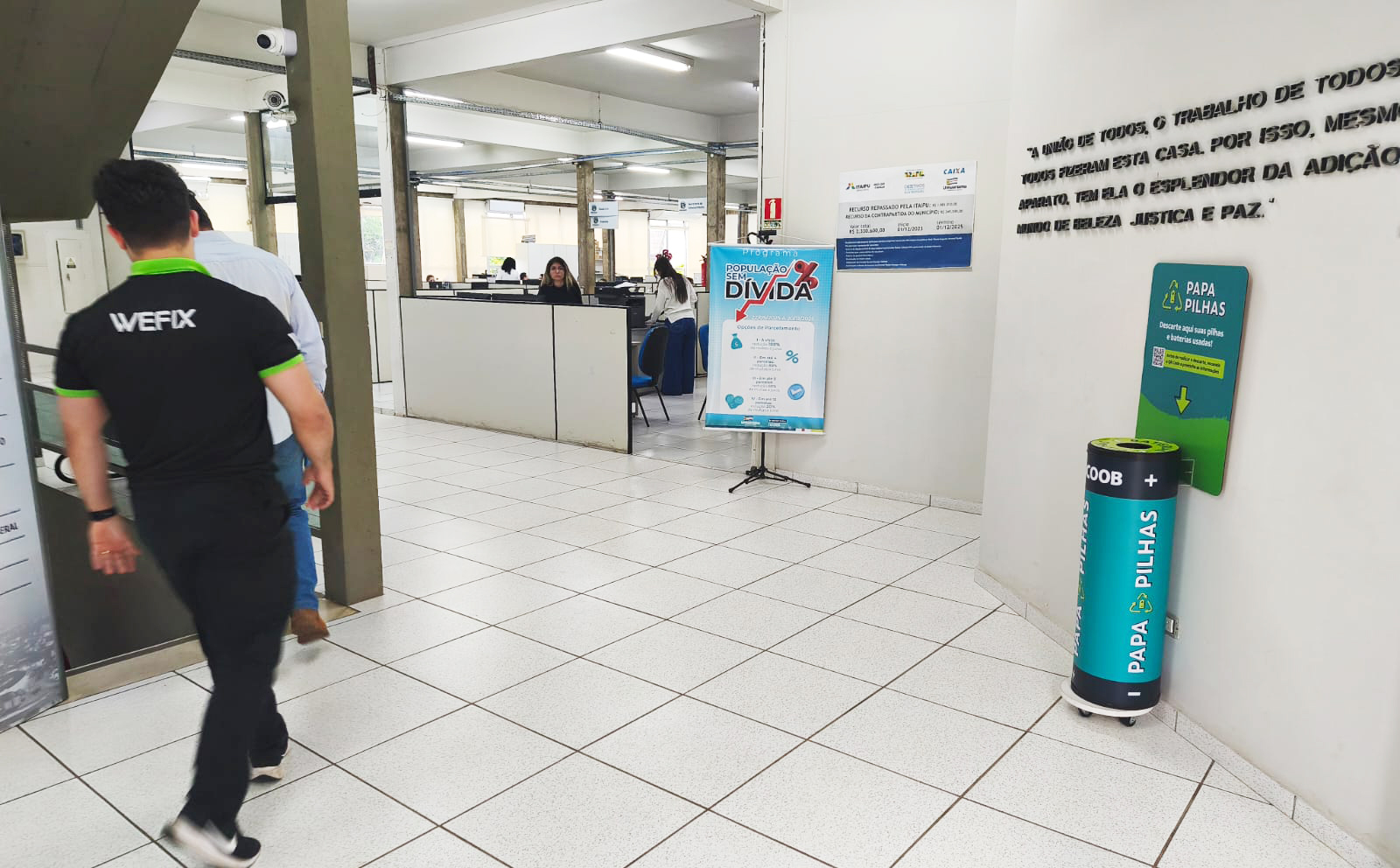 setor de negociação de dívidas na prefeitura, com banner do programa