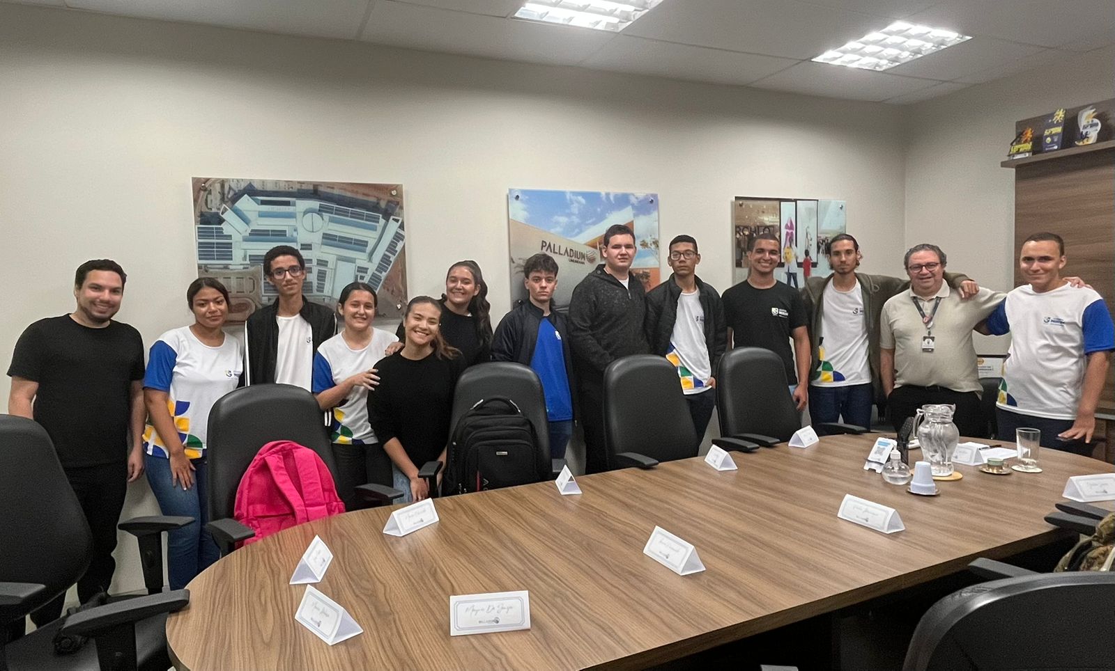 jovens participantes do programa reunidos em sala com superintendente do shopping