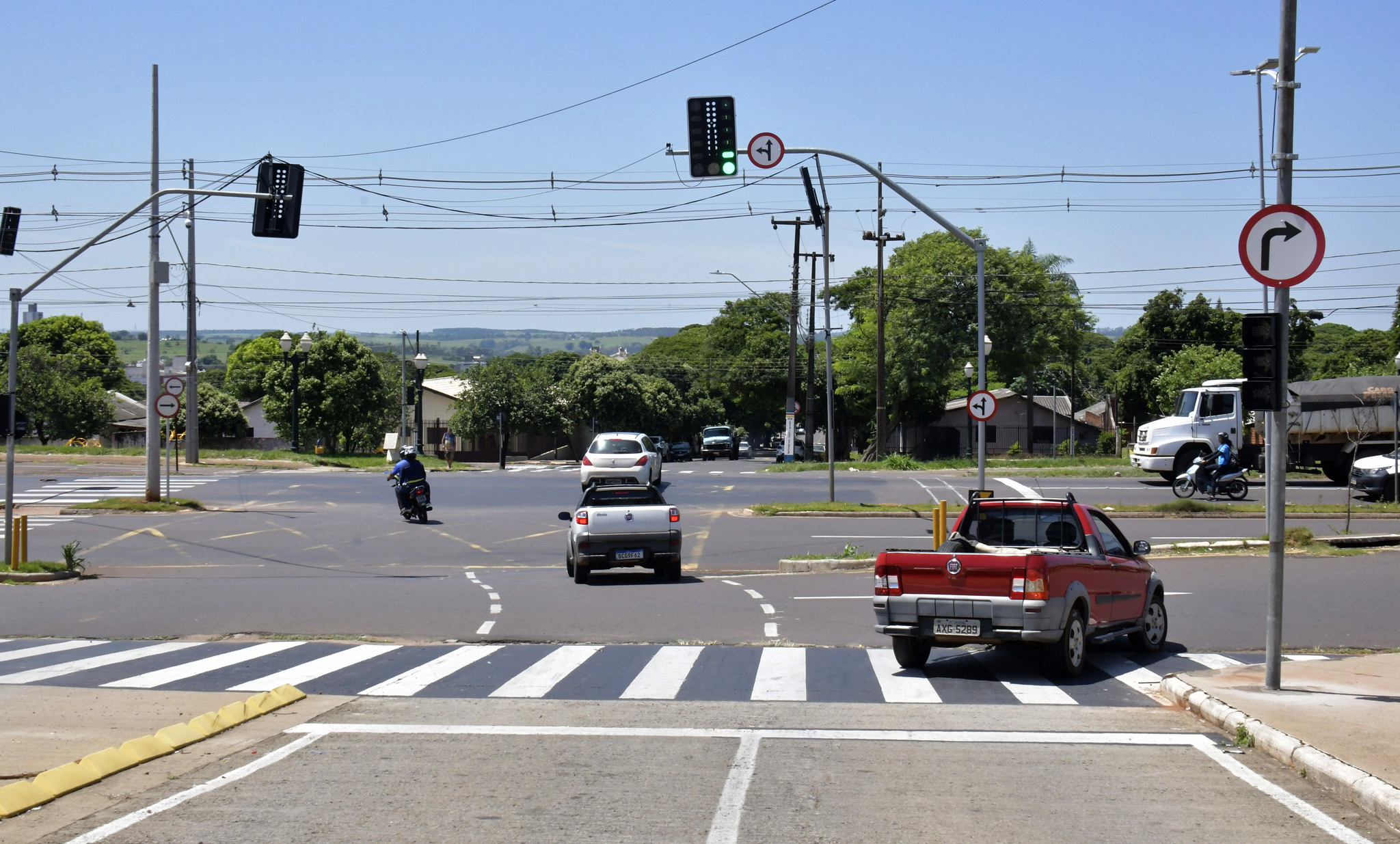 imagem de cruzamento de avenida sinalizado com semáforo e placas