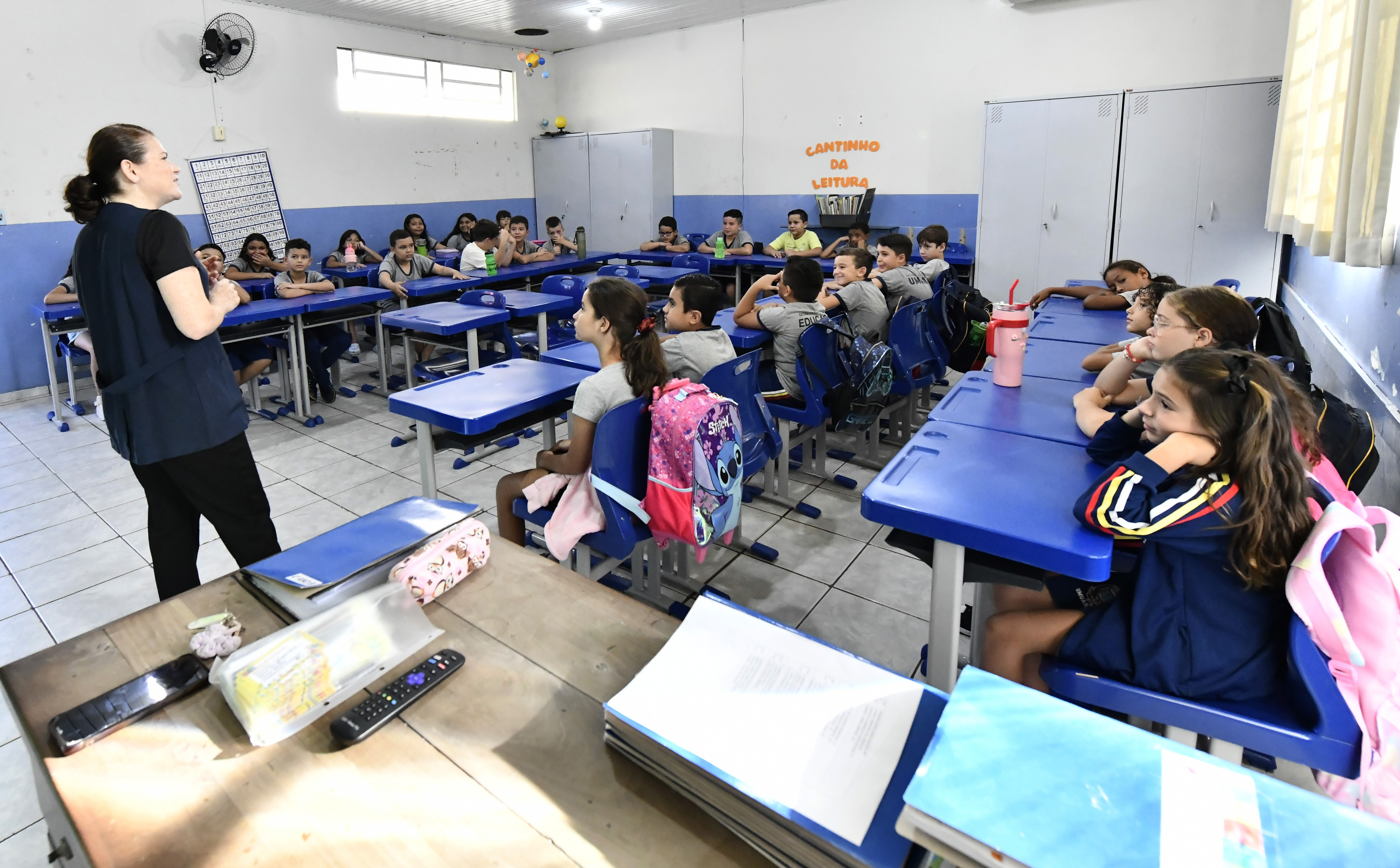 professora em sala de aula com alunos nas carteiras