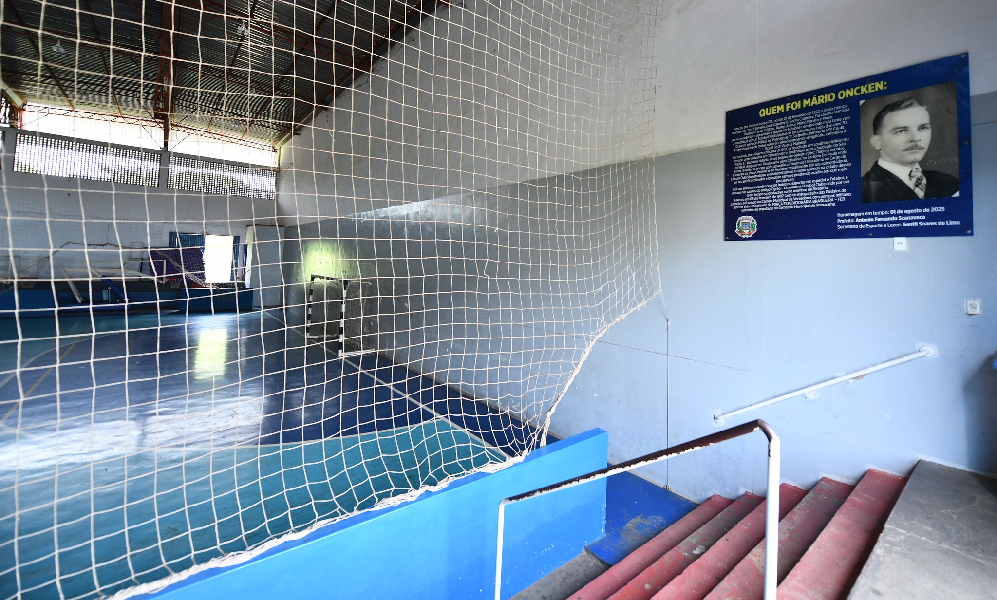 imagem parcial do ginásio de esportes com o painel fixo na parede