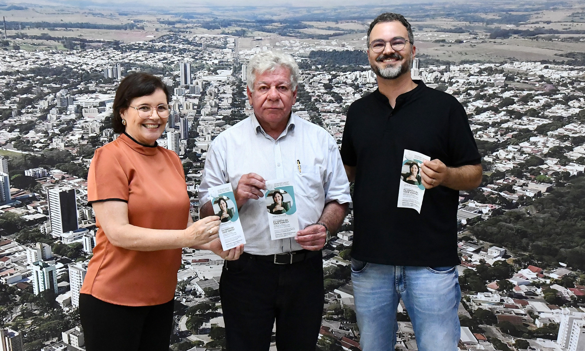 prefeito, secretário e terapeuta exibem panfleto do projeto
