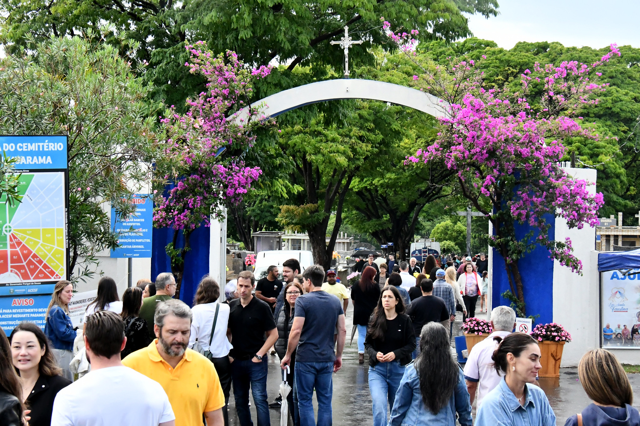 grande movimento de pessoas no portão do cemitério municipal