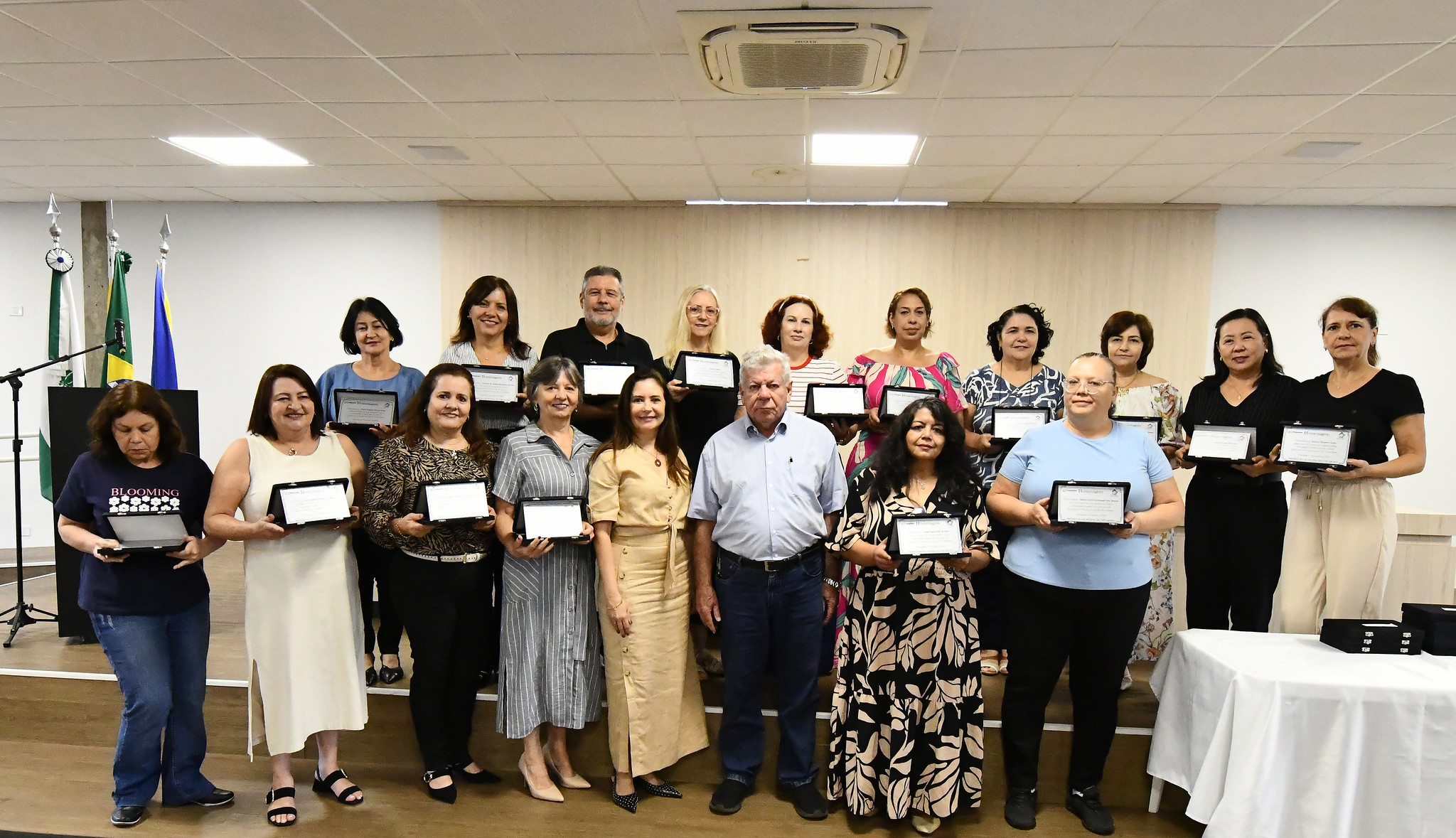aposentados posam com placas de homenagem recebidas da prefeitura