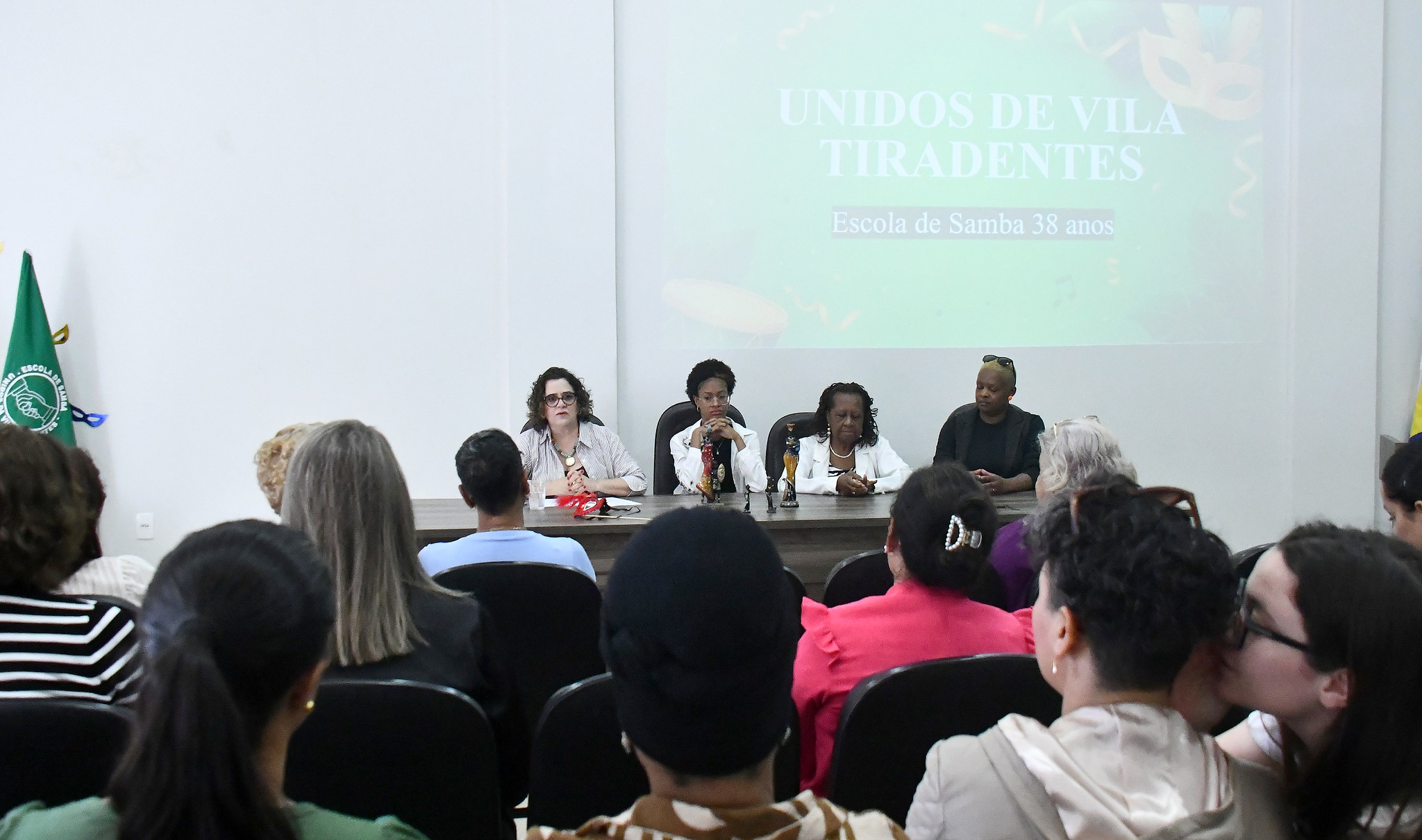 mesa de honra do evento, com convidadas diante do público