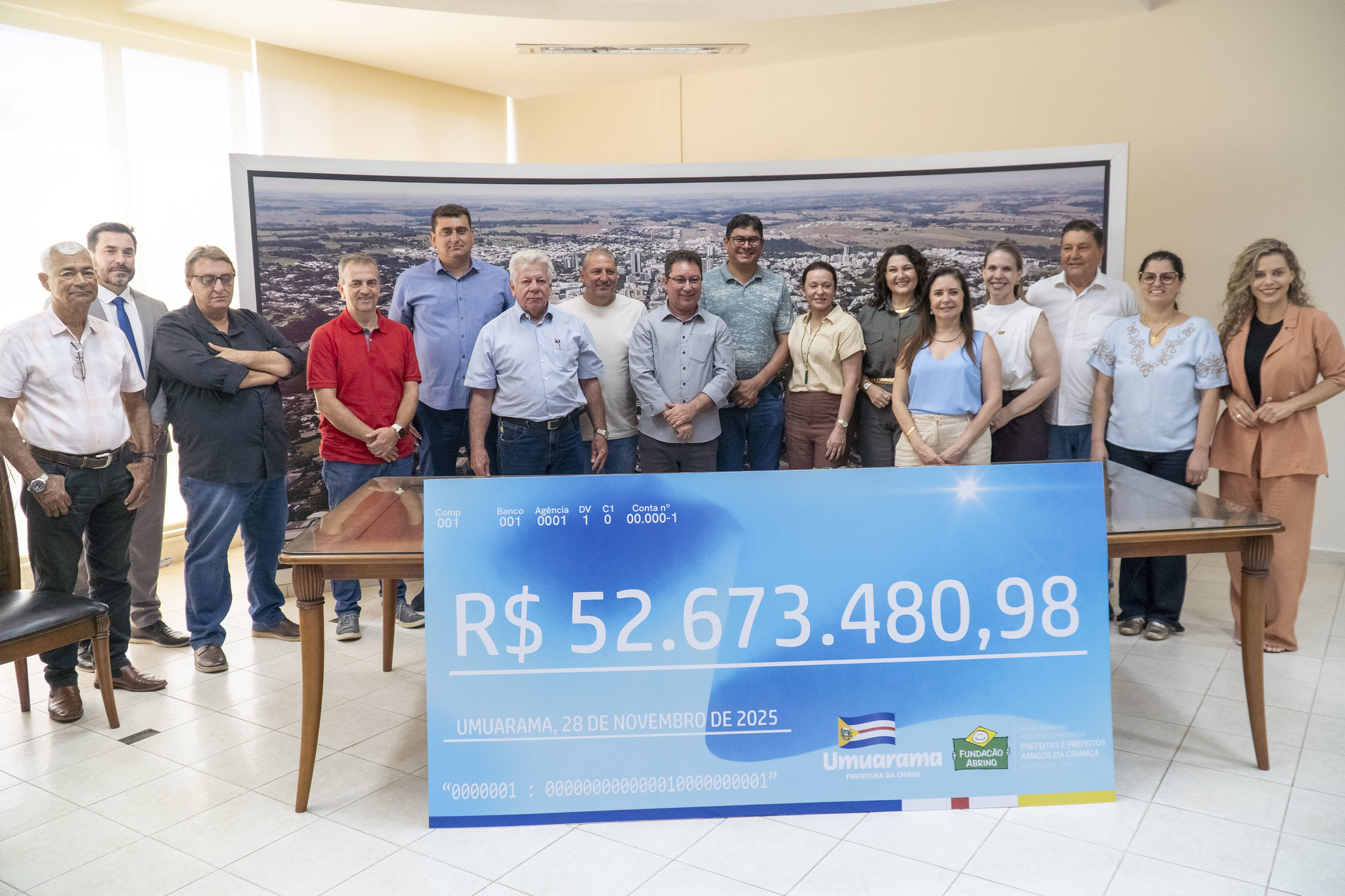 prefeito e autoridades mostram cheque simbólico com o valor dos vencimentos repassados ao funcionalismo