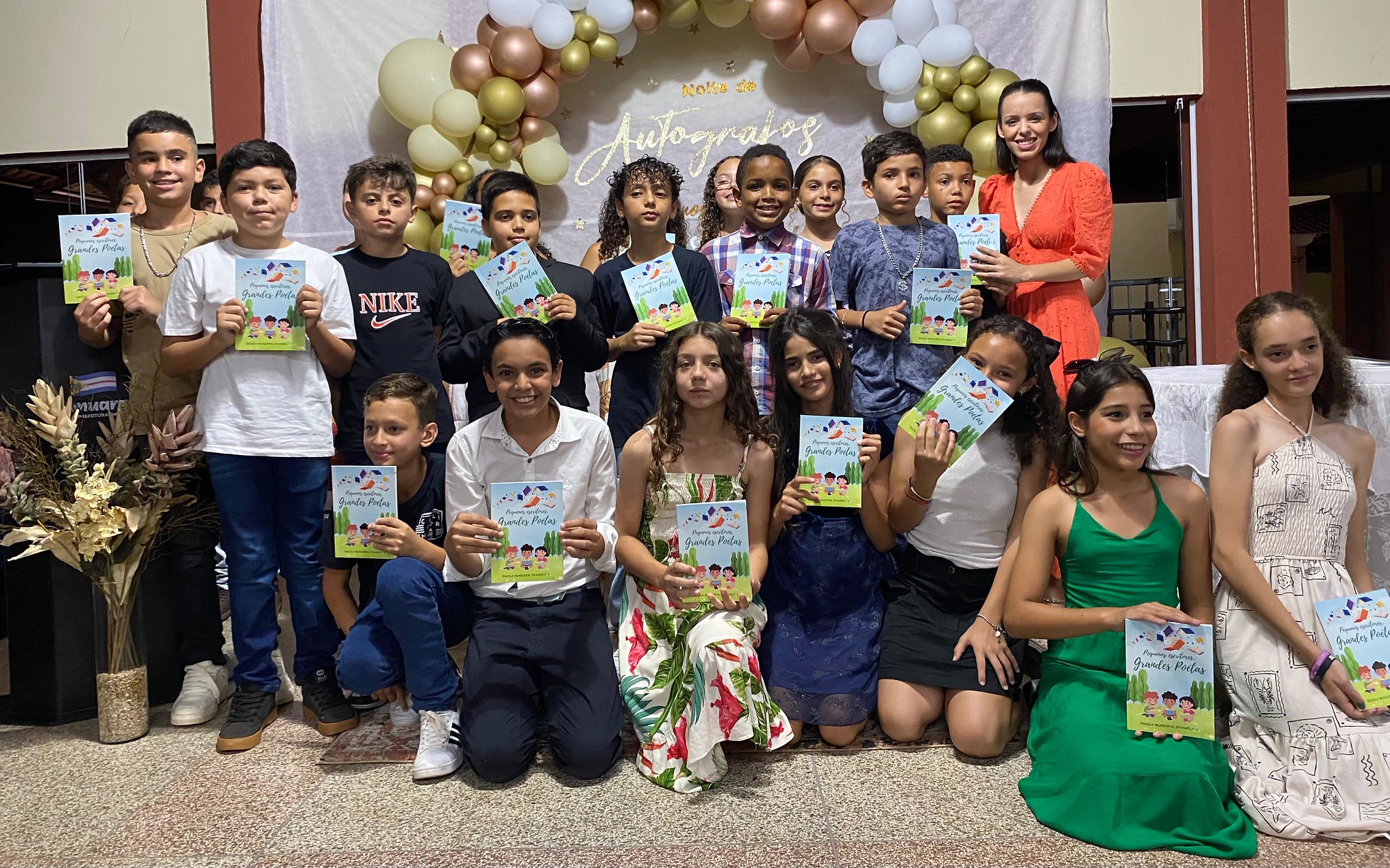 crianças mostram livro de poesia que escreveram