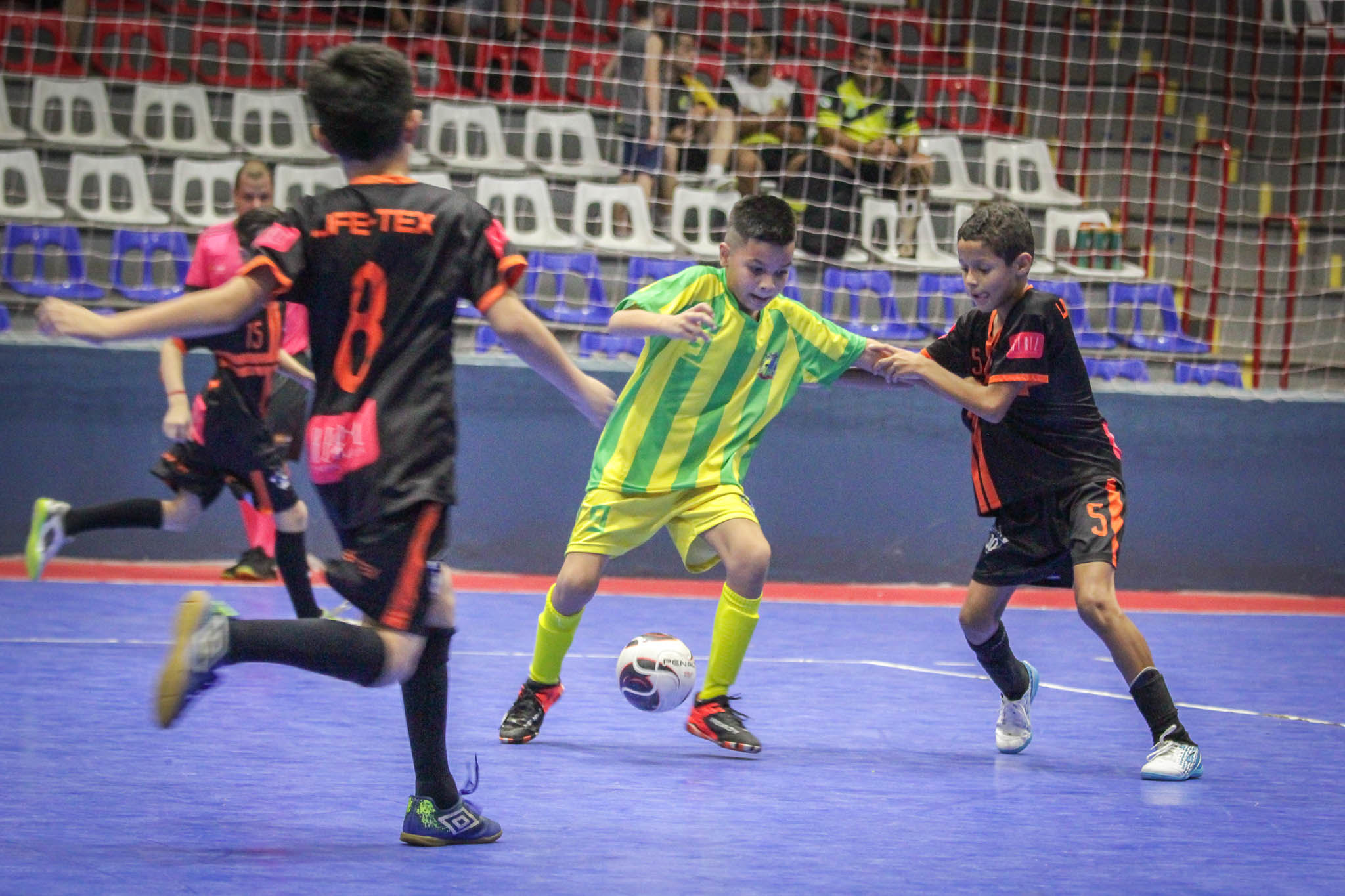 crianças jogando futsal na quadra